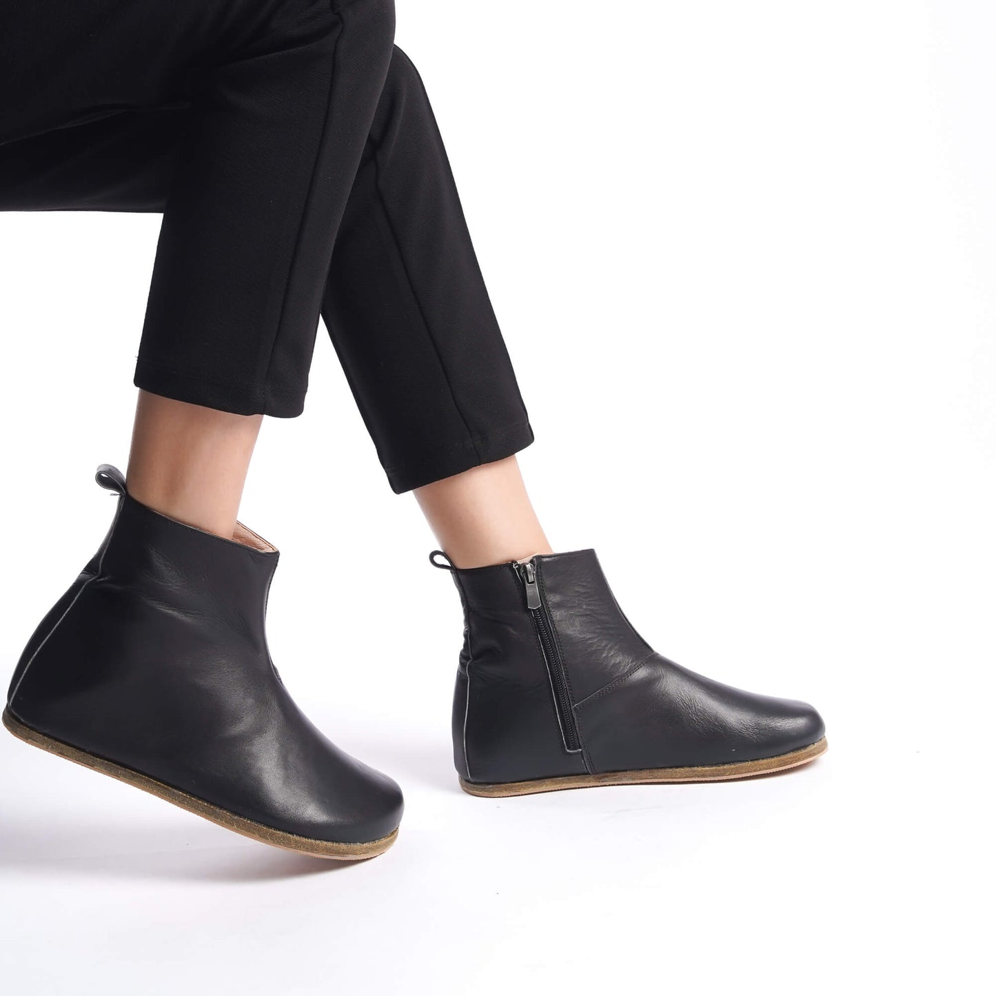 Sleek black leather wide boots for women, featuring ergonomic soles. Ideal for minimalist style and earthing comfort.