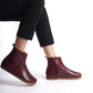 Burgundy leather wide boots for women, featuring ergonomic soles and a minimalist design for comfortable earthing.