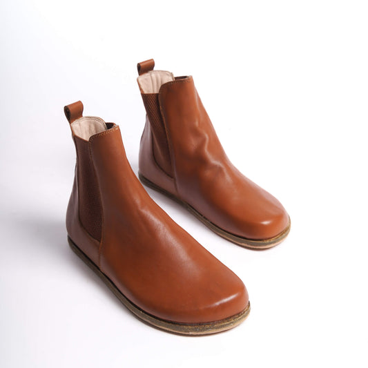 Tan brown Chelsea boots for women with a wide toe box, made from natural leather. Perfect for a minimalist look and comfort.
