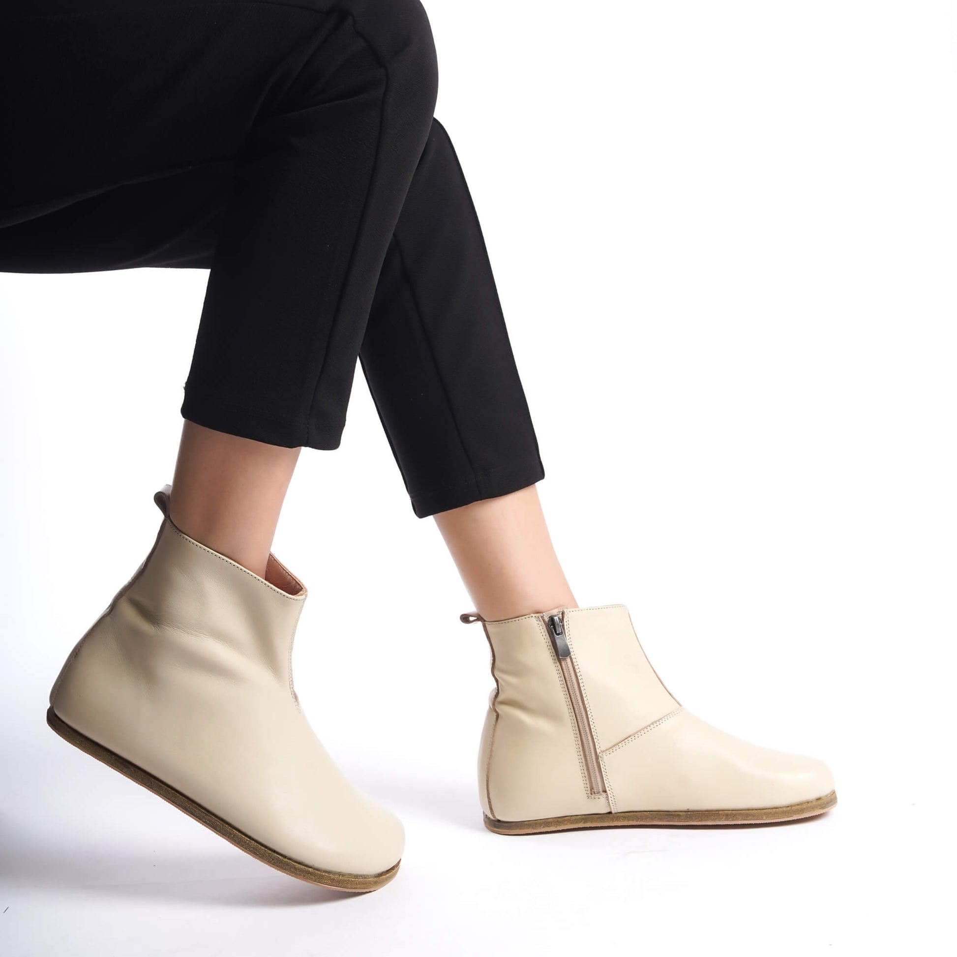 Cream leather wide boots for women, featuring ergonomic soles and a minimalist design for comfortable earthing.