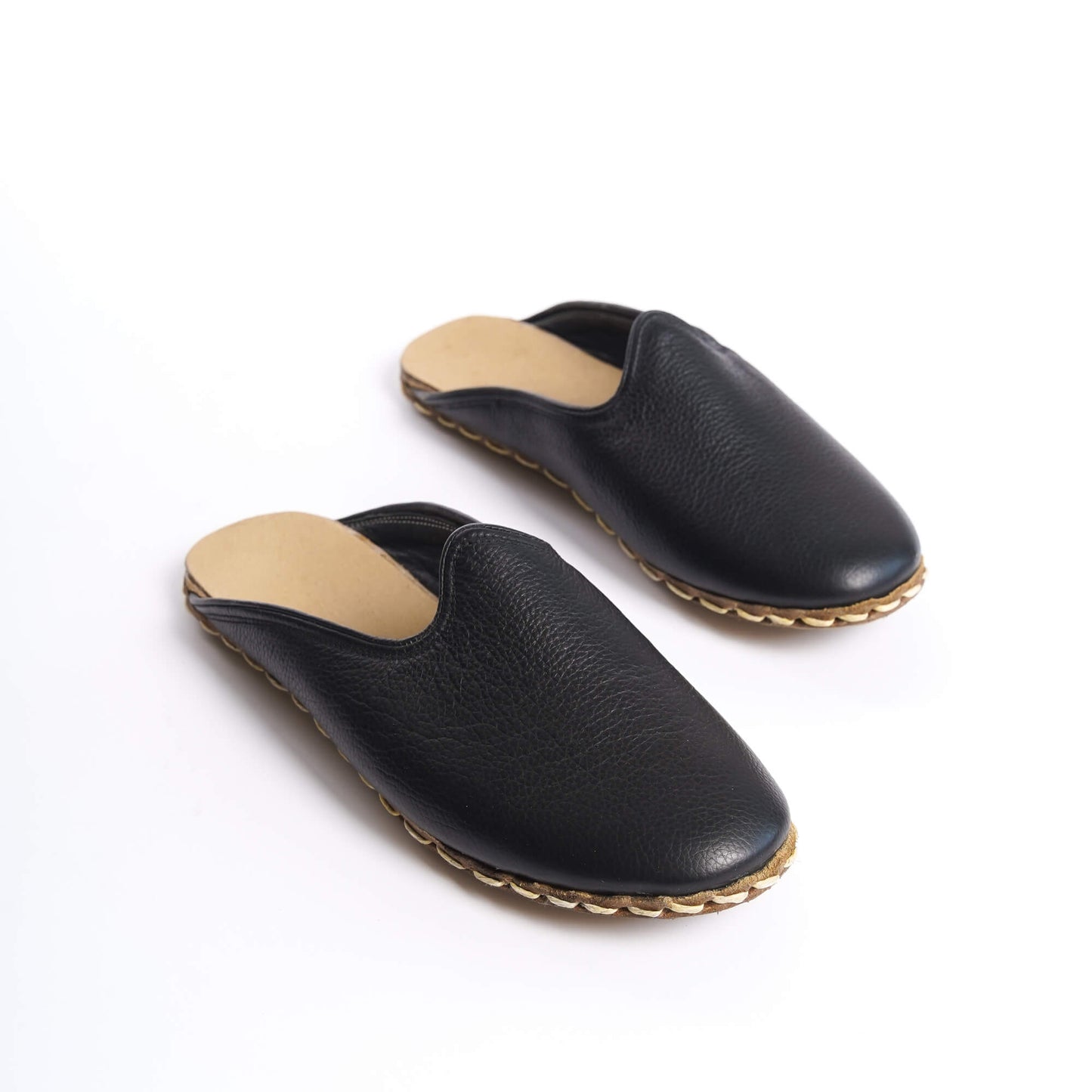 High-quality black leather women's mules with elegant stitching.