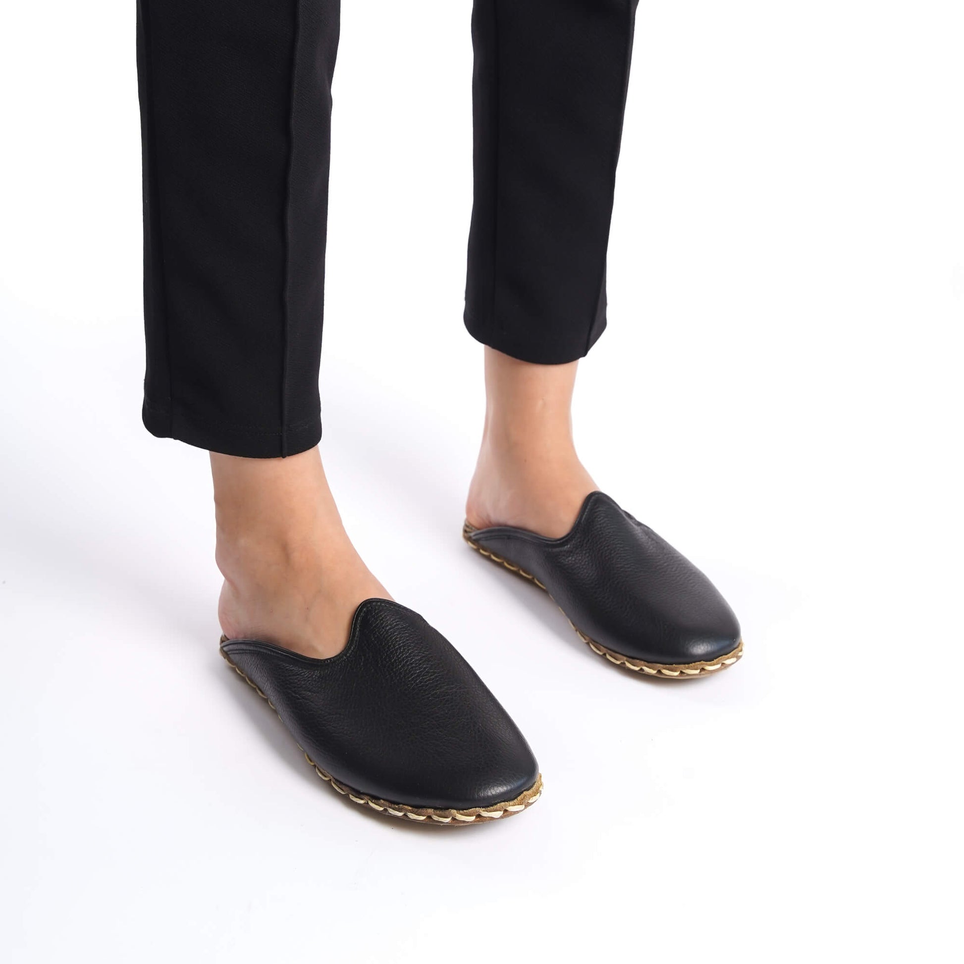 Luxurious black leather mules for women, featuring meticulous stitch work.