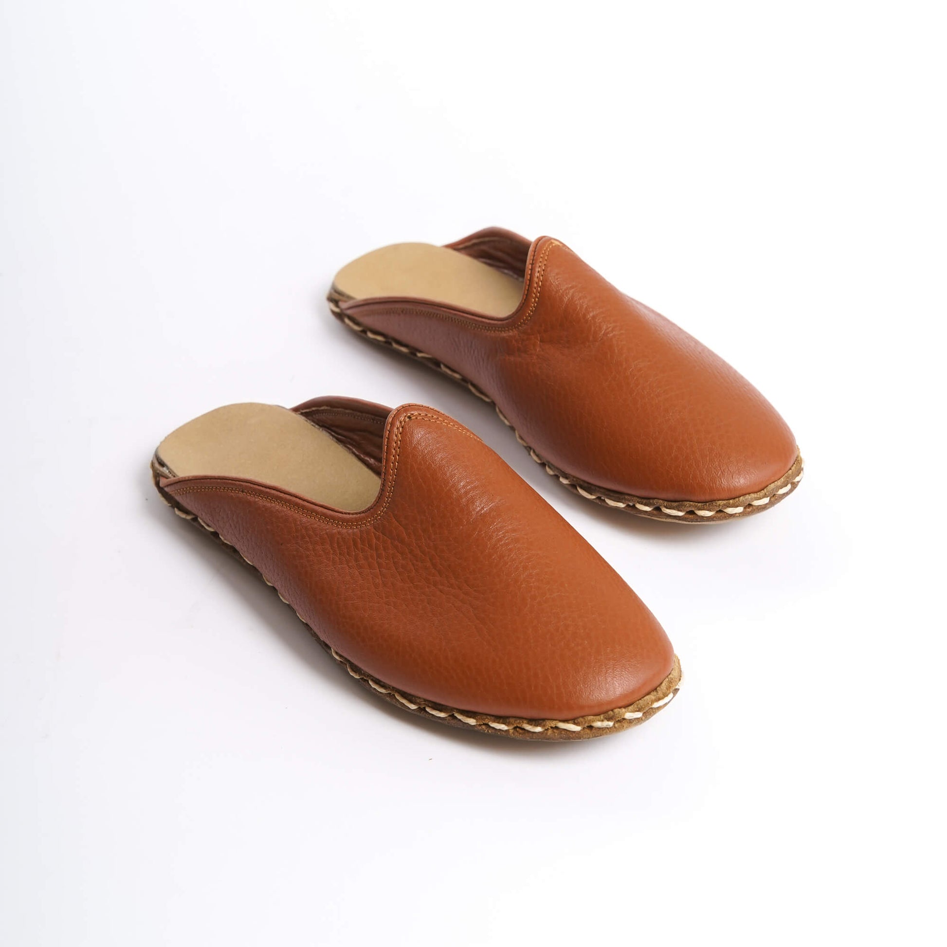Handcrafted genuine leather summer slippers in tan with precise stitching.