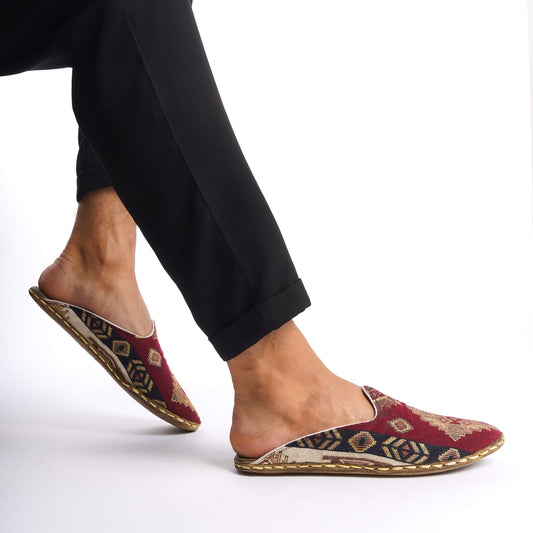 Person wearing traditional Turkish slippers with a red and yellow geometric pattern.