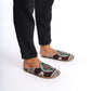Person standing in traditional Turkish slippers with intricate green, red, and white patterns.