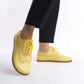 Model showcasing Doris Leather Barefoot Women's Oxfords in Yellow with detailed stitching, paired with black pants