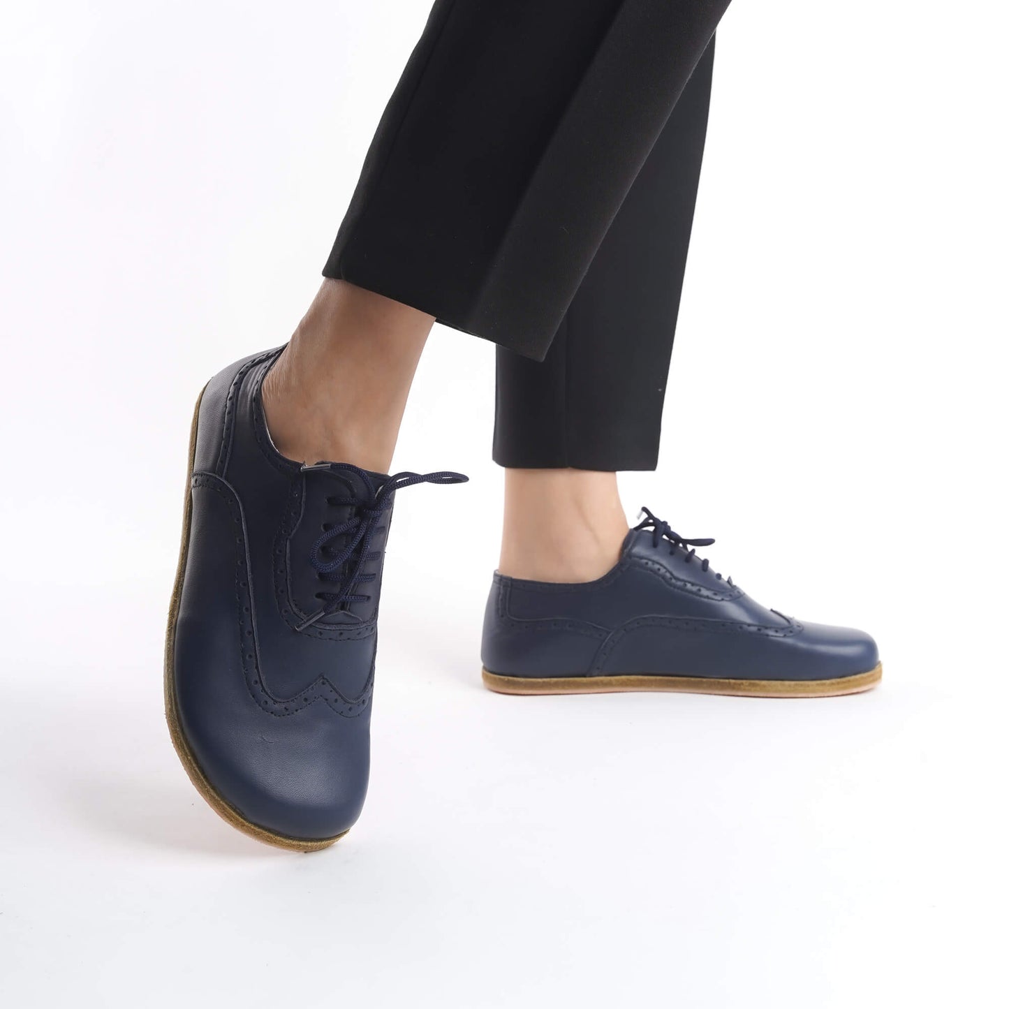 Model showcasing Doris Leather Barefoot Women's Oxfords in Navy Blue with detailed stitching, paired with black pants