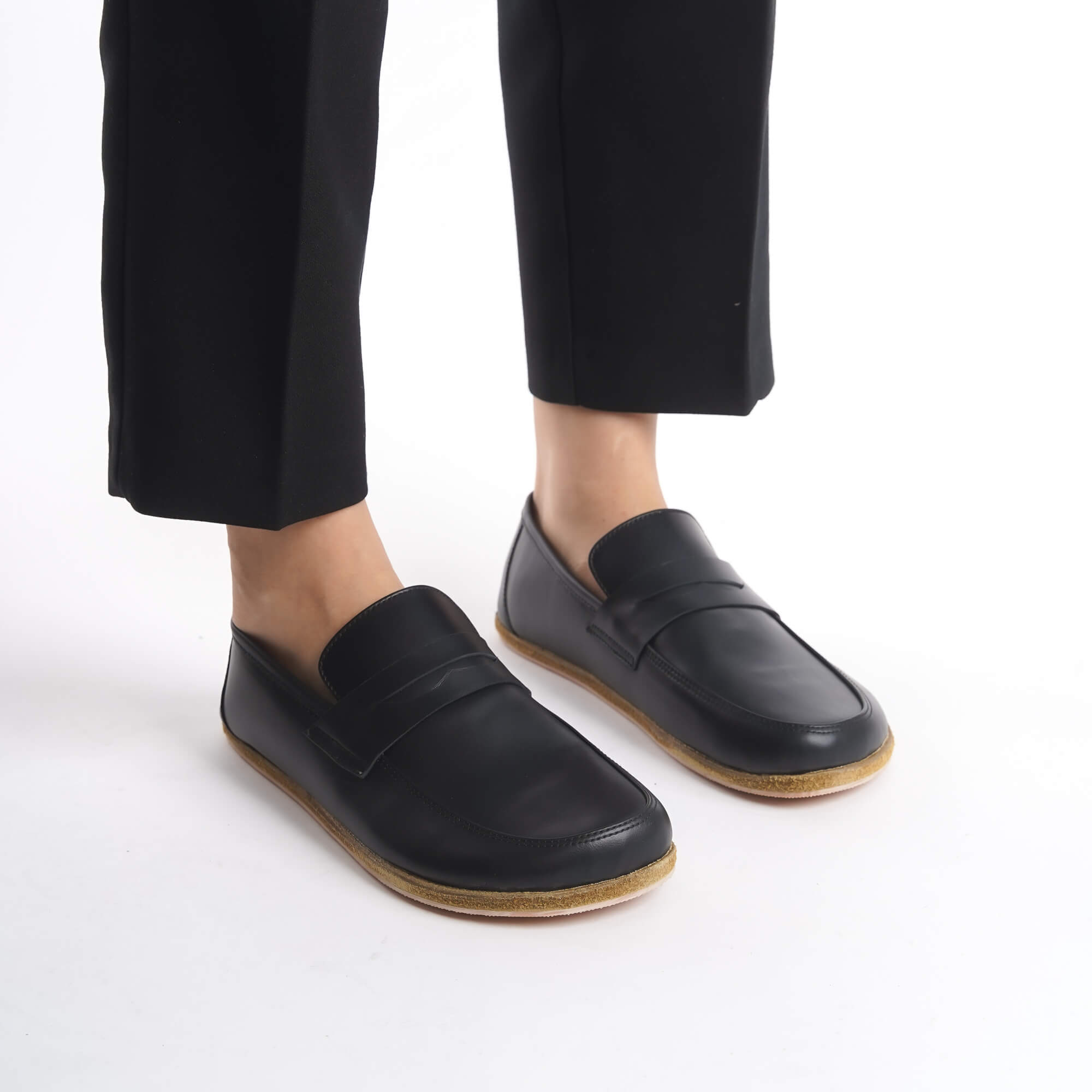 Minimalist black barefoot penny loafers by Pelanir in motion. Featuring a zero-drop sole and natural foot flexibility for effortless walking.