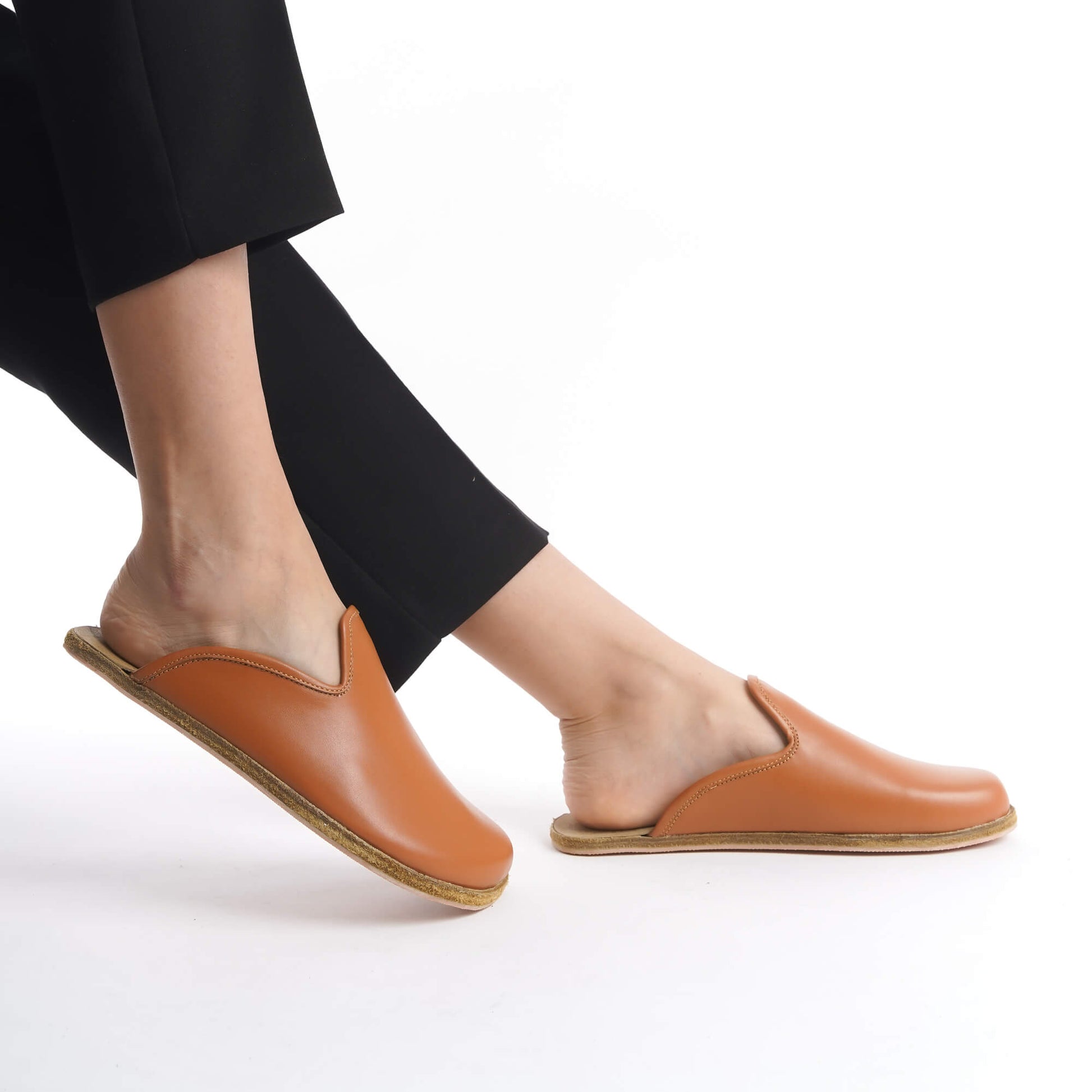 Earthy tan leather slip-on shoes with a supportive cork sole, designed for women who value sustainability and style. These lightweight, breathable shoes are a must-have for any U.S. wardrobe.