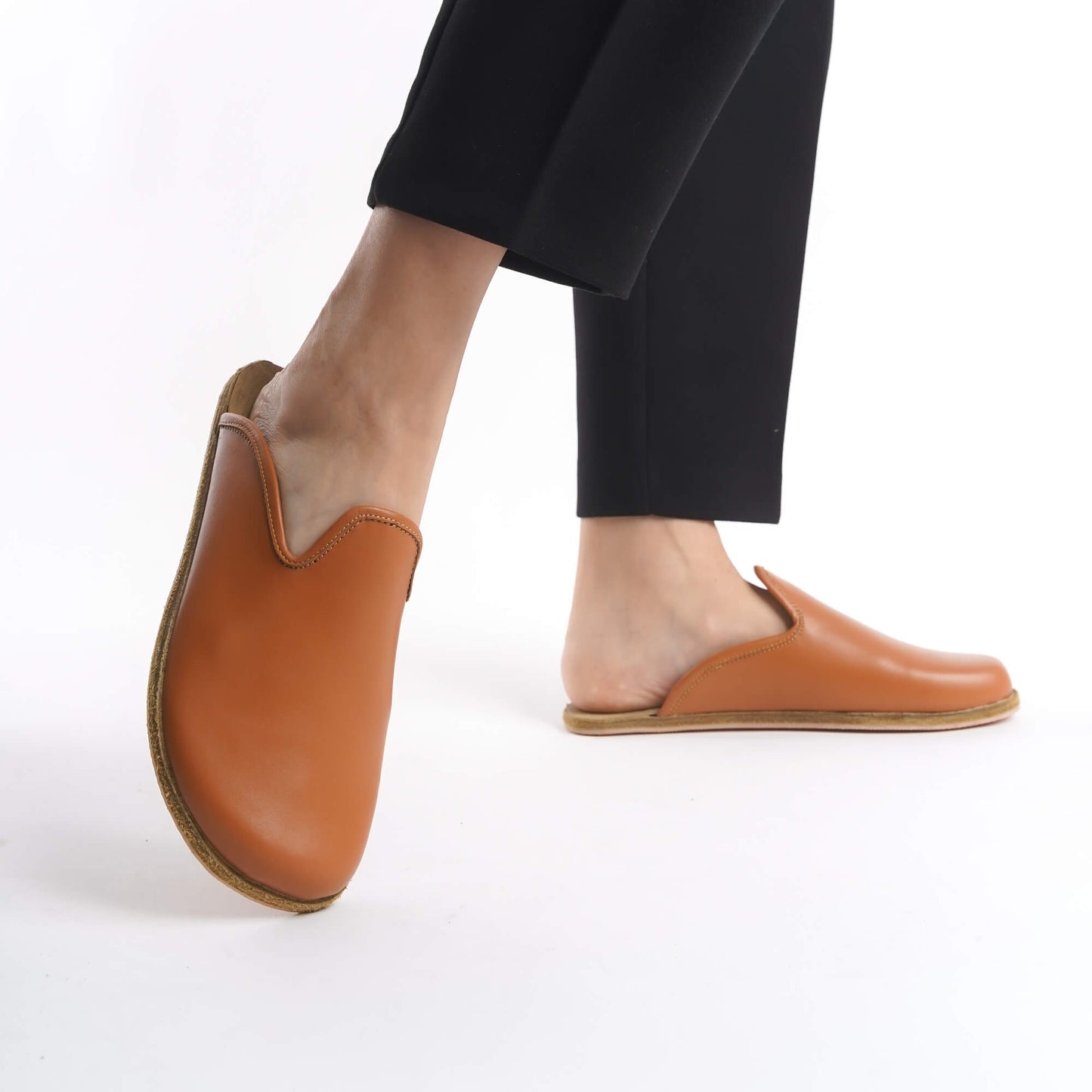 Rustic tan leather slip-on shoes for women, crafted with a natural cork sole for superior arch support. These durable and eco-conscious shoes are ideal for casual outings in the USA