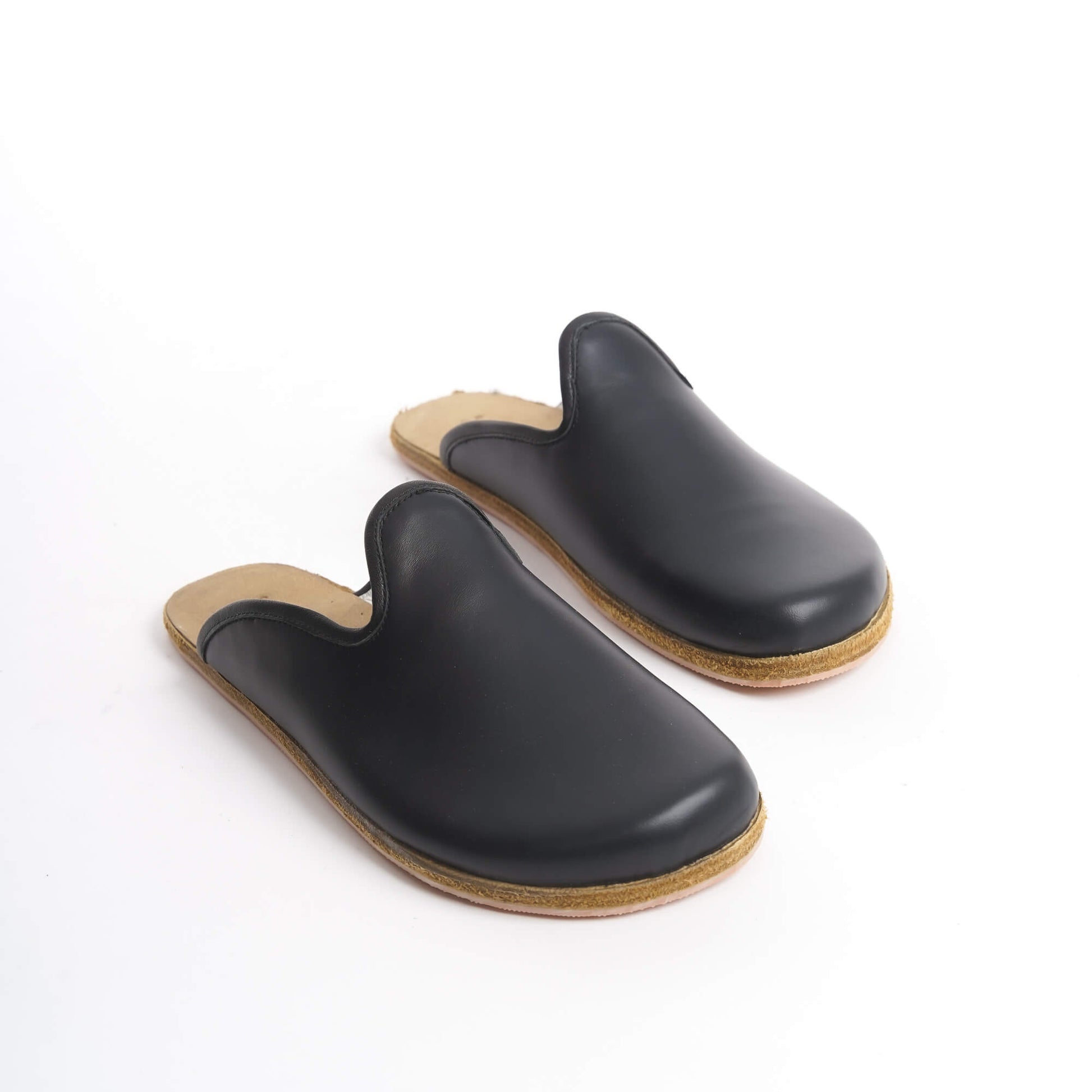 Elegant black leather slip-on shoes with a cushioned cork sole, designed for women seeking timeless footwear. These eco-friendly and durable shoes are perfect for the U.S. fashion scene.