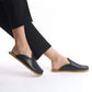 Timeless black leather slip-on shoes with a supportive cork sole, designed for women seeking versatile style. These lightweight, sustainable shoes are a staple for any U.S. wardrobe.