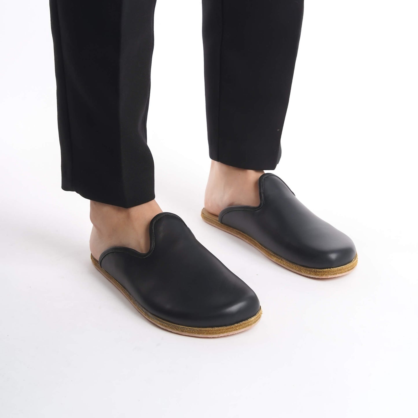 Sleek black leather slip-on shoes featuring a cozy cork sole, perfect for women’s professional and casual looks. These sustainable shoes offer flexibility and comfort, appealing to U.S. shoppers.