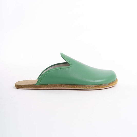 Vibrant green leather slip-on shoes for women, featuring a supportive cork sole for all-day comfort. These eco-friendly and bold shoes are ideal for U.S. trendsetters looking to make a statement.