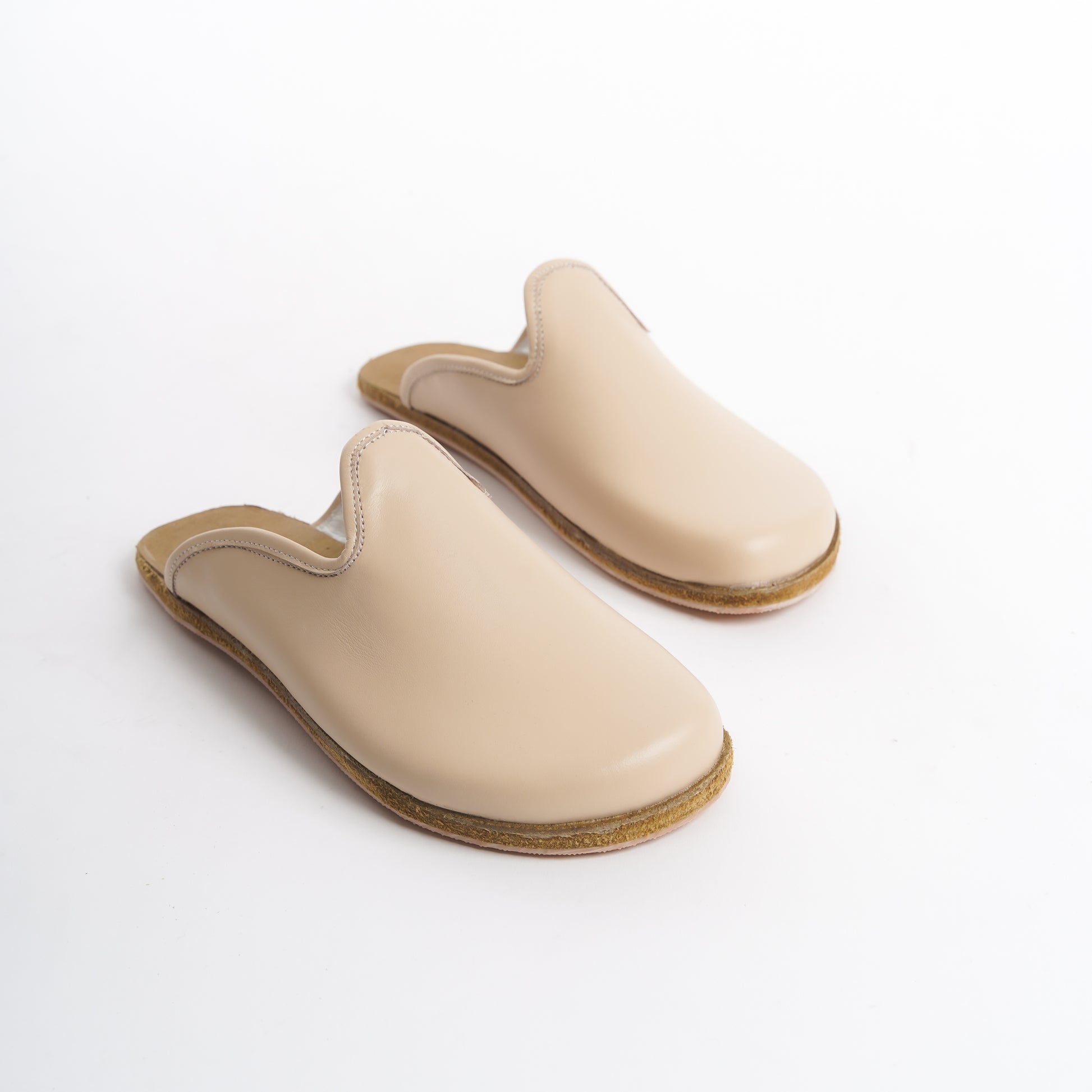 Elegant cream leather slip-on shoes with a cushioned cork sole, designed for women seeking trendy footwear. These eco-friendly shoes combine luxury and durability, perfect for the U.S. market.