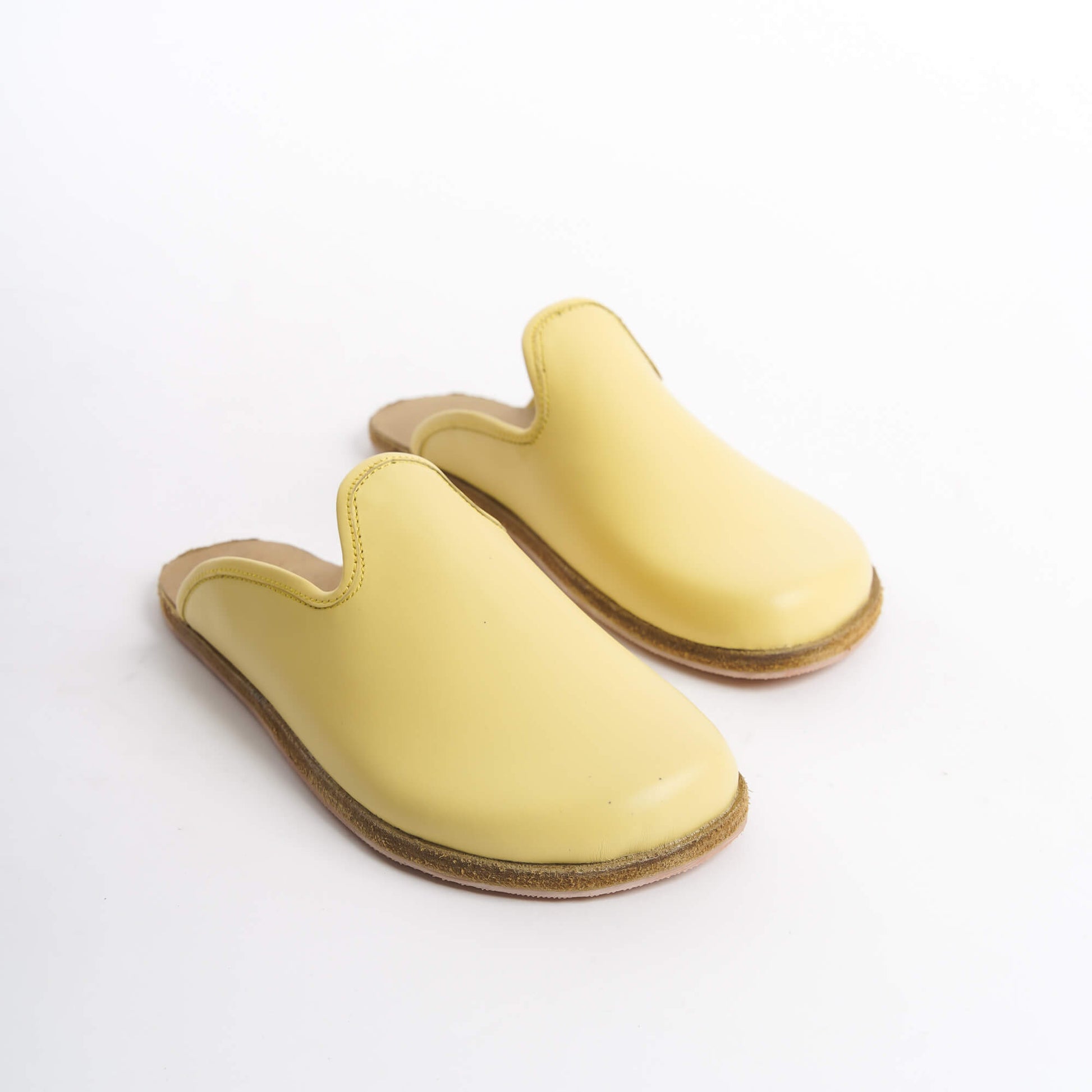 Vivid yellow leather slip-on shoes with a supportive cork sole, designed for women who embrace bold trends. These eco-friendly and comfortable shoes are a must-have for the U.S. market.