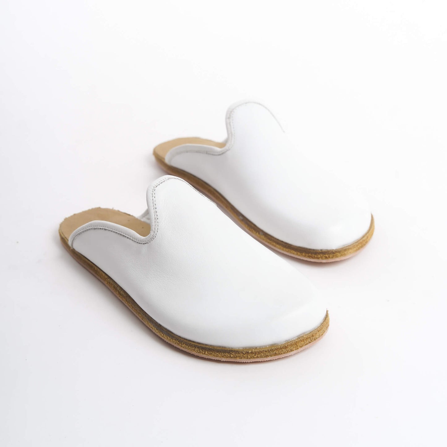 Sophisticated white leather slip-on shoes featuring a cozy cork sole, designed for women’s everyday elegance. Perfect for the U.S. market, these lightweight, eco-friendly shoes provide excellent support and pair well with any outfit.