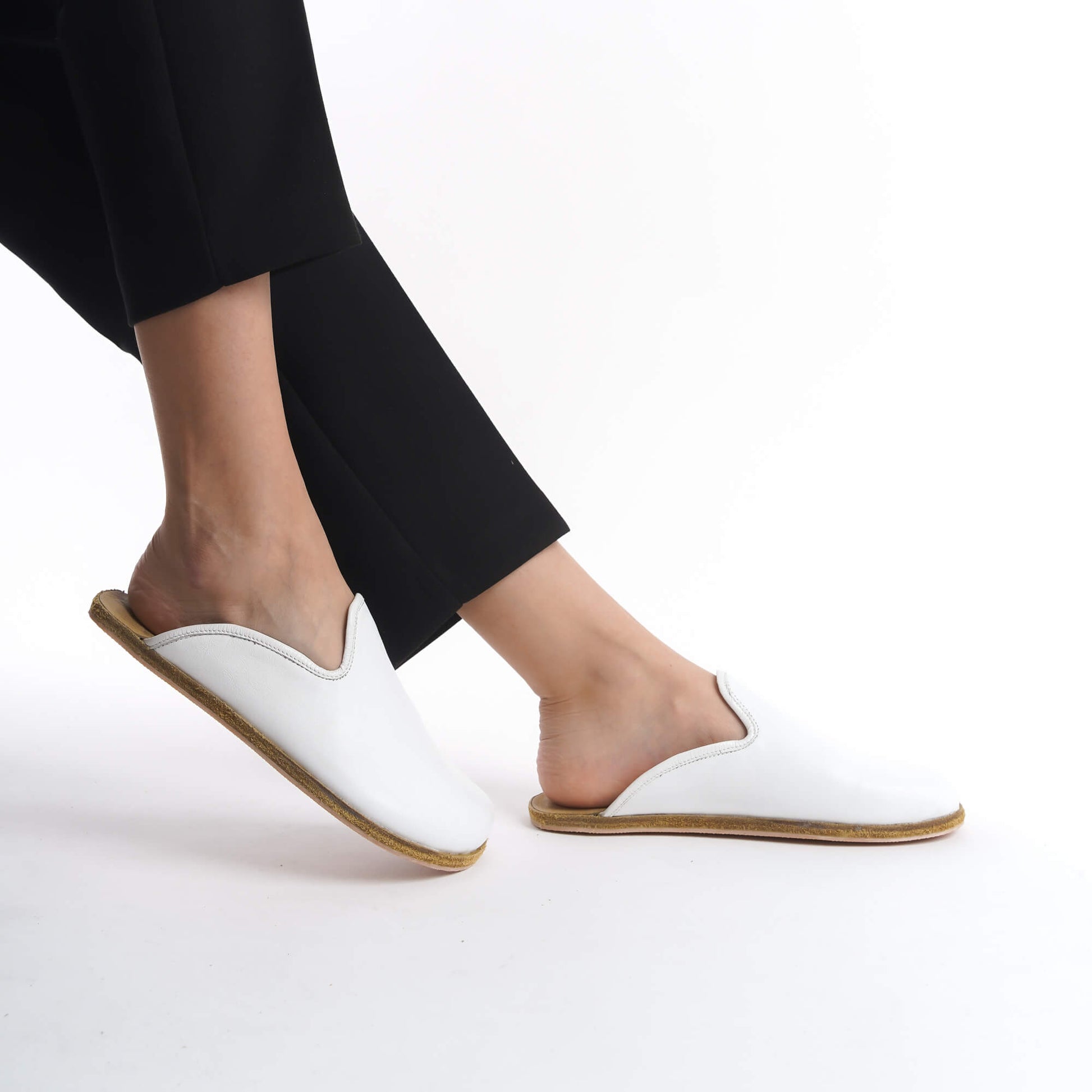 Elegant white leather slip-on shoes with a supportive cork sole, designed for women seeking comfort and style. These sustainable footwear options enhance any wardrobe, offering flexibility and a lightweight feel for daily use in the U.S. market.