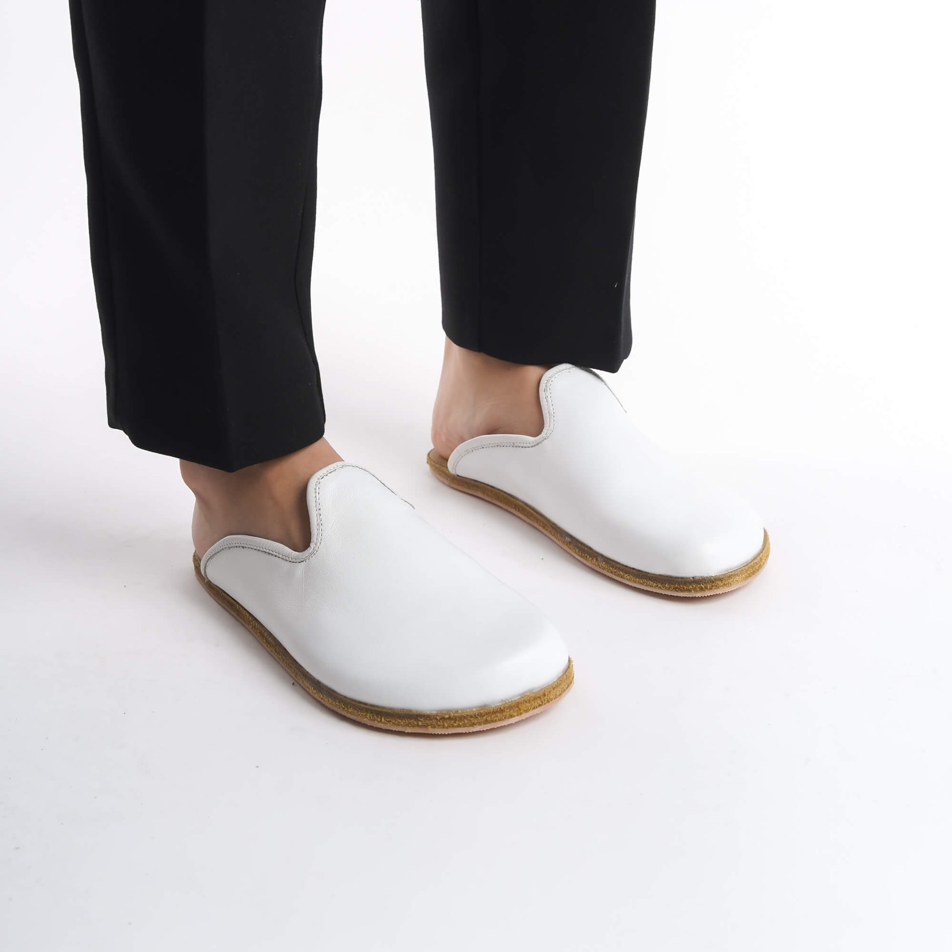 Chic white leather slip-on shoes for women, crafted with a natural cork sole for superior comfort and arch support. Ideal for American fashion enthusiasts, these versatile shoes combine luxury and eco-conscious materials for all-day wear.