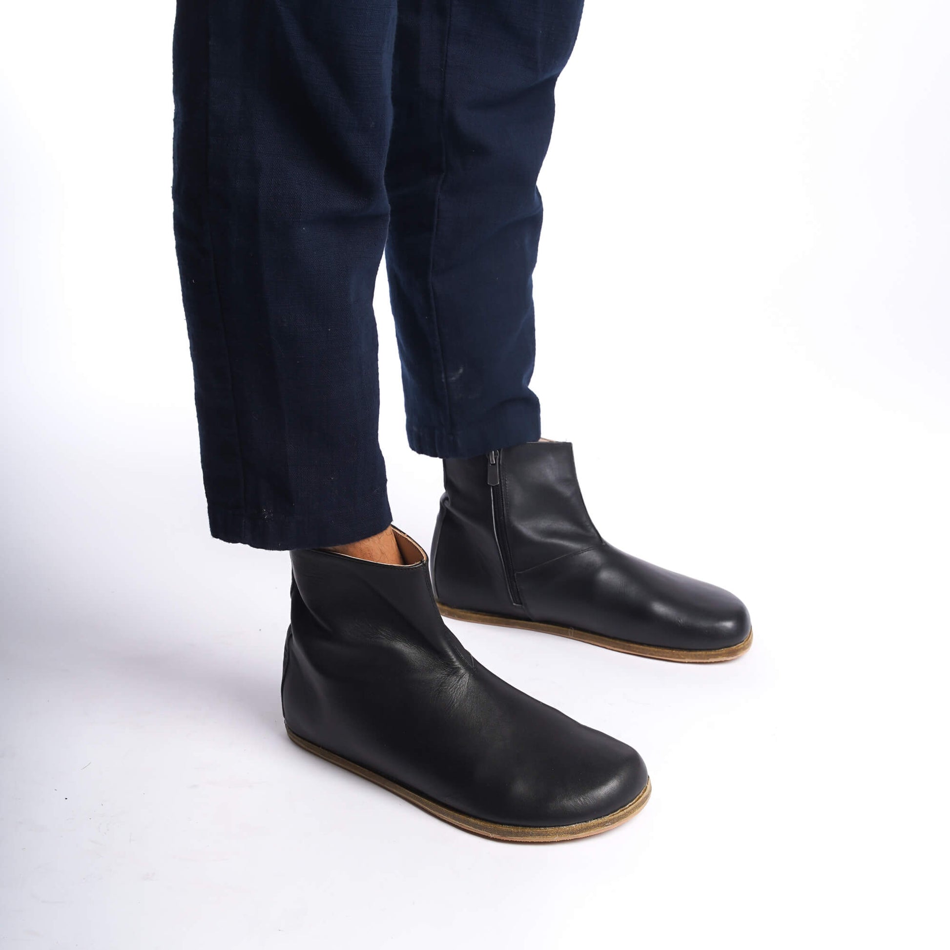 Side view of men's black ankle boots, showcasing the minimalist design and premium leather construction.