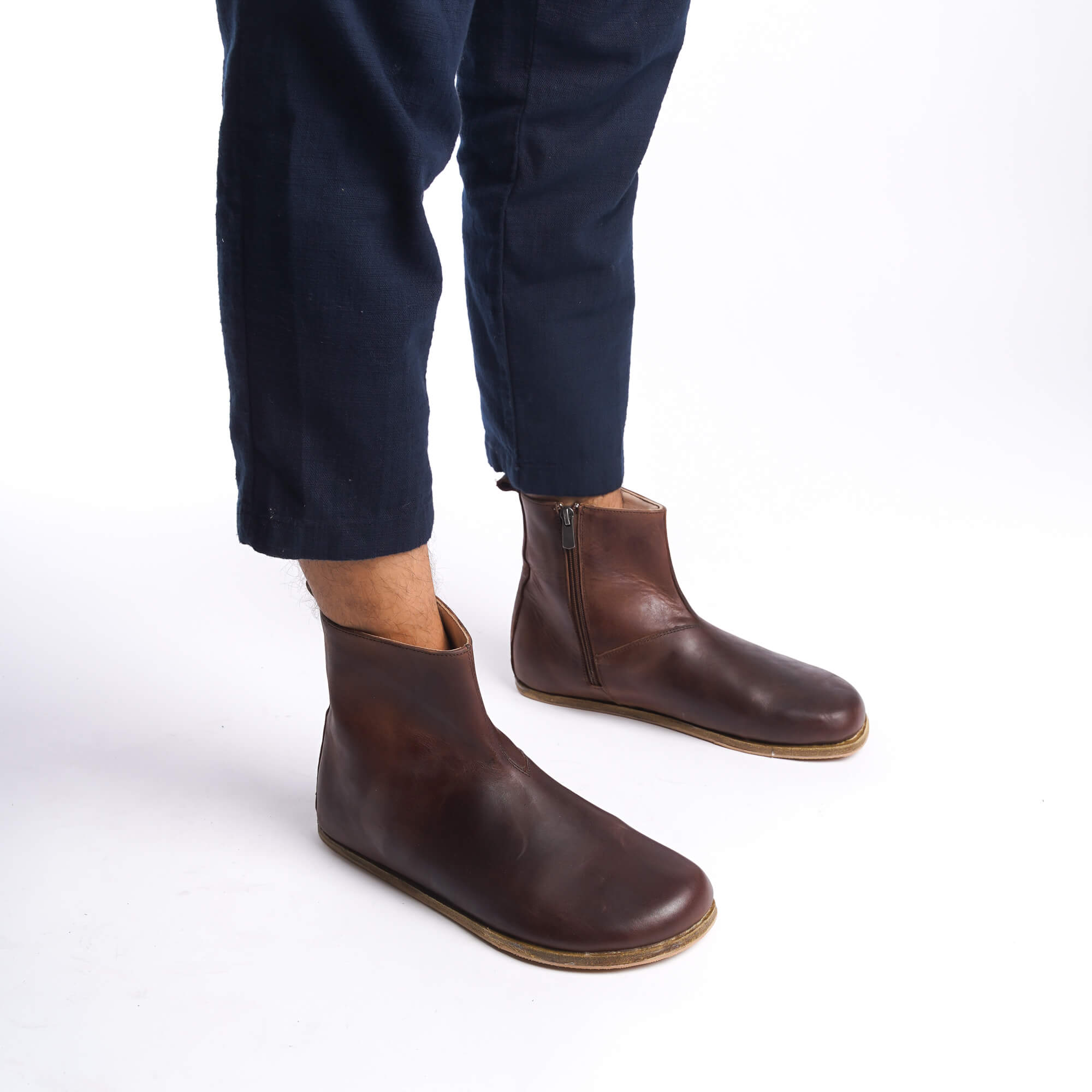 Side view of men's brown ankle boots, highlighting the minimalist design and high-quality leather material.