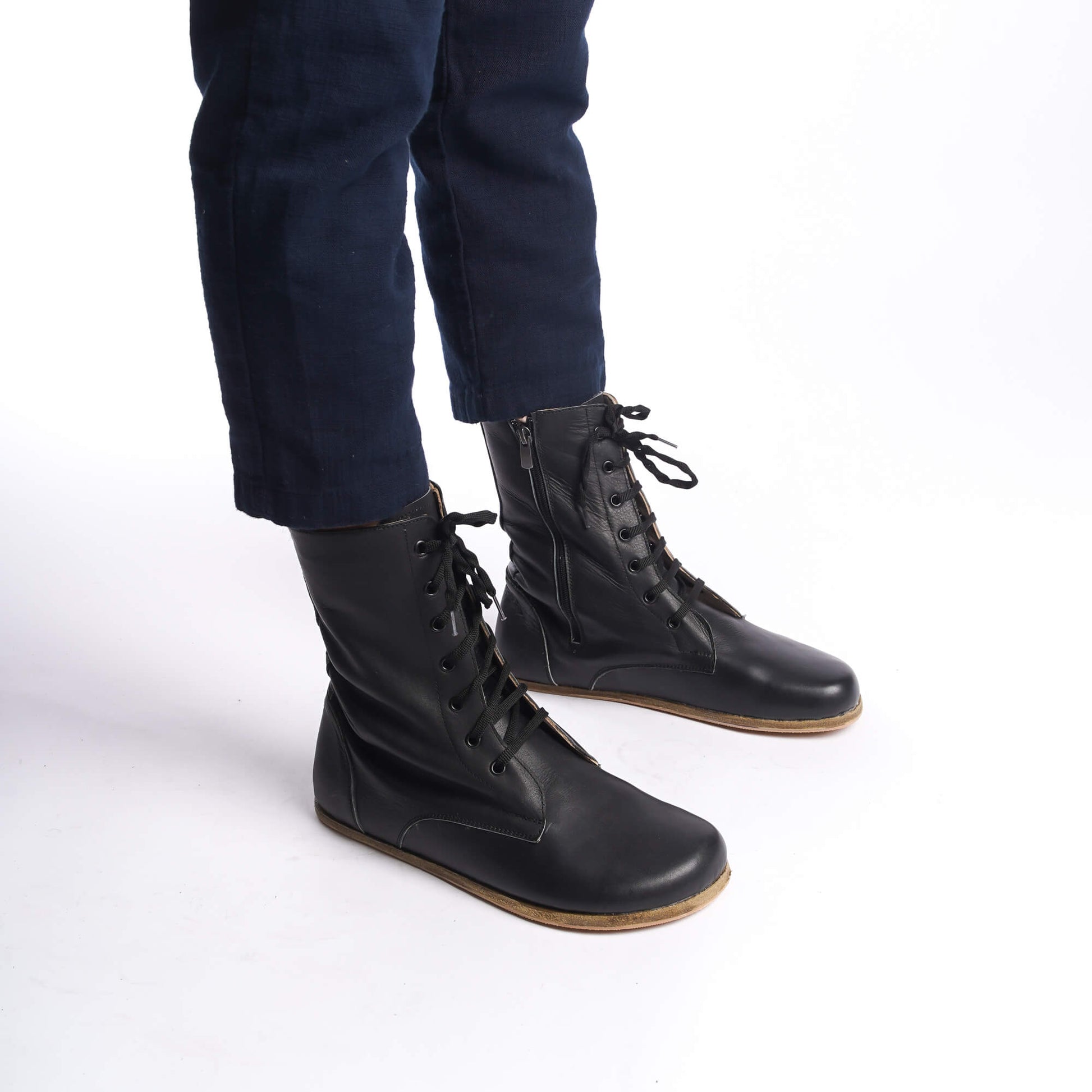 Side view of men's black barefoot boots, emphasizing the lace-up design and premium leather.