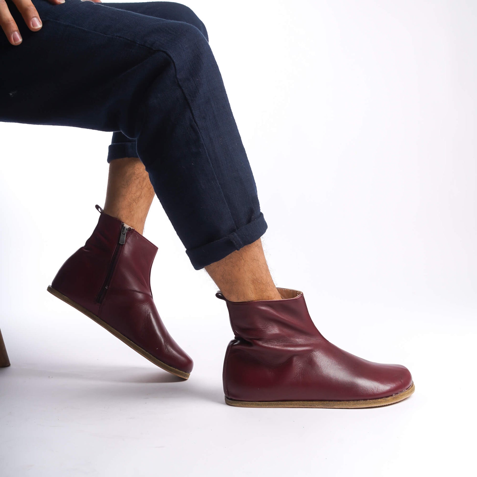 Side view of men's burgundy ankle boots, showcasing the minimalist design and rich leather material.