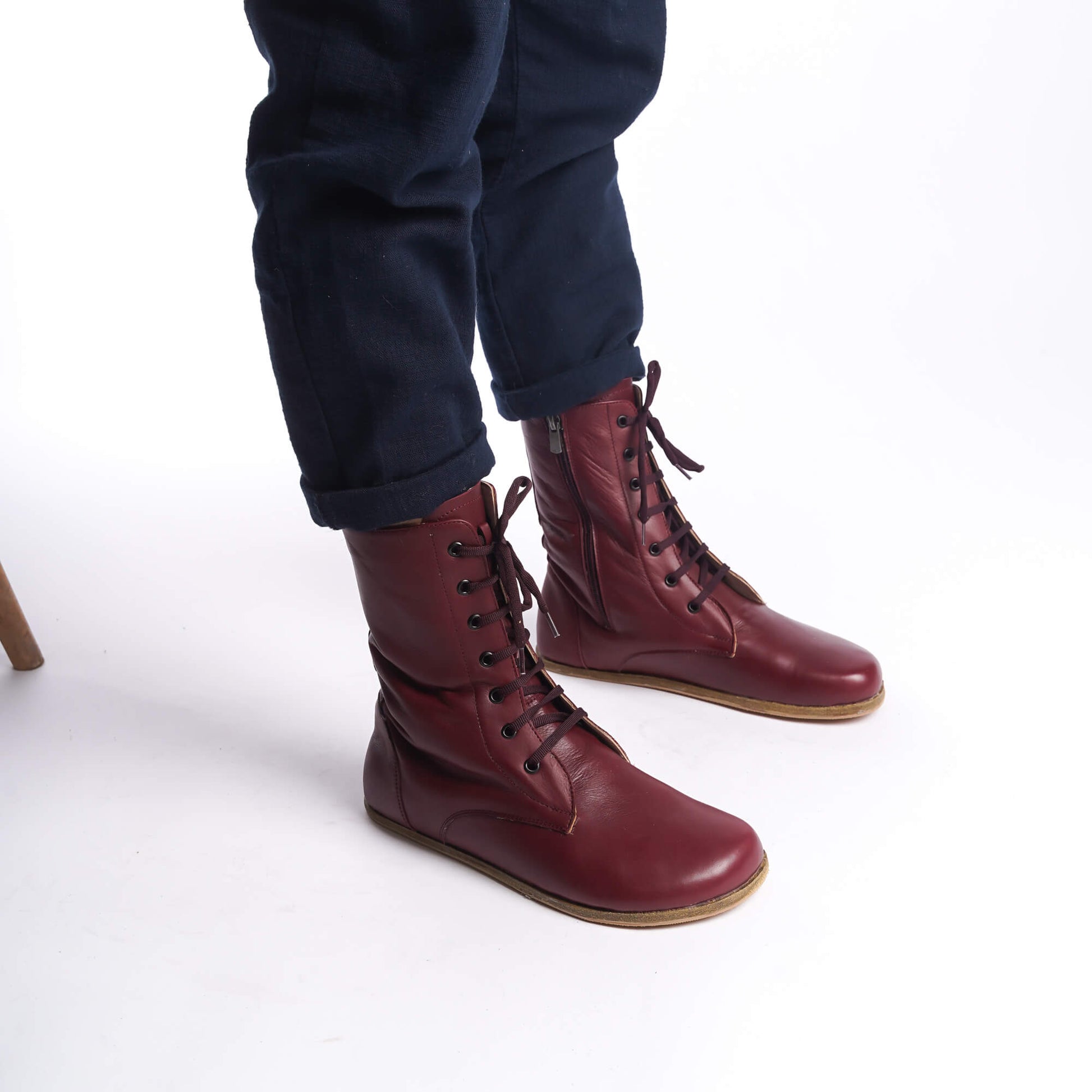 Side view of men's burgundy barefoot boots, highlighting the lace-up design and rich leather.