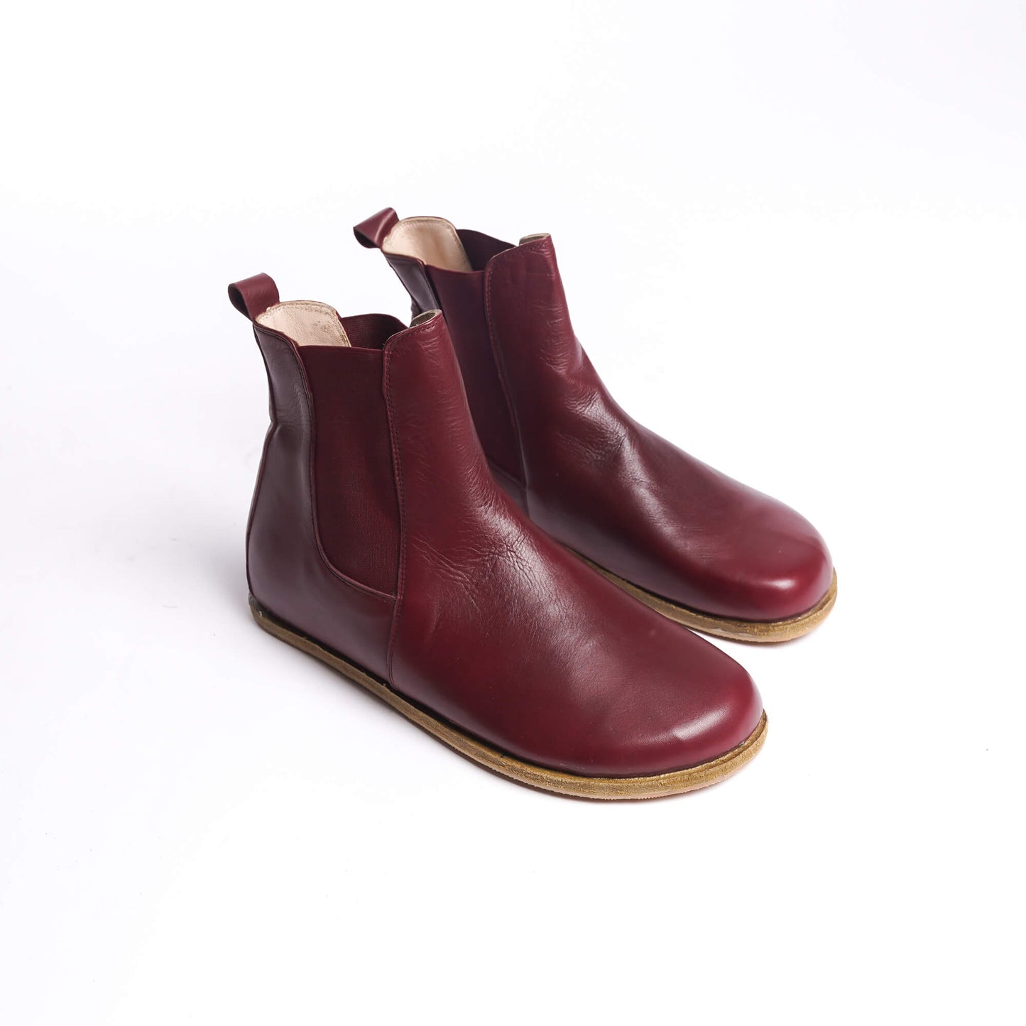 Pair of men's burgundy Chelsea boots, made from genuine leather with elastic side panels for a sophisticated and comfortable fit.