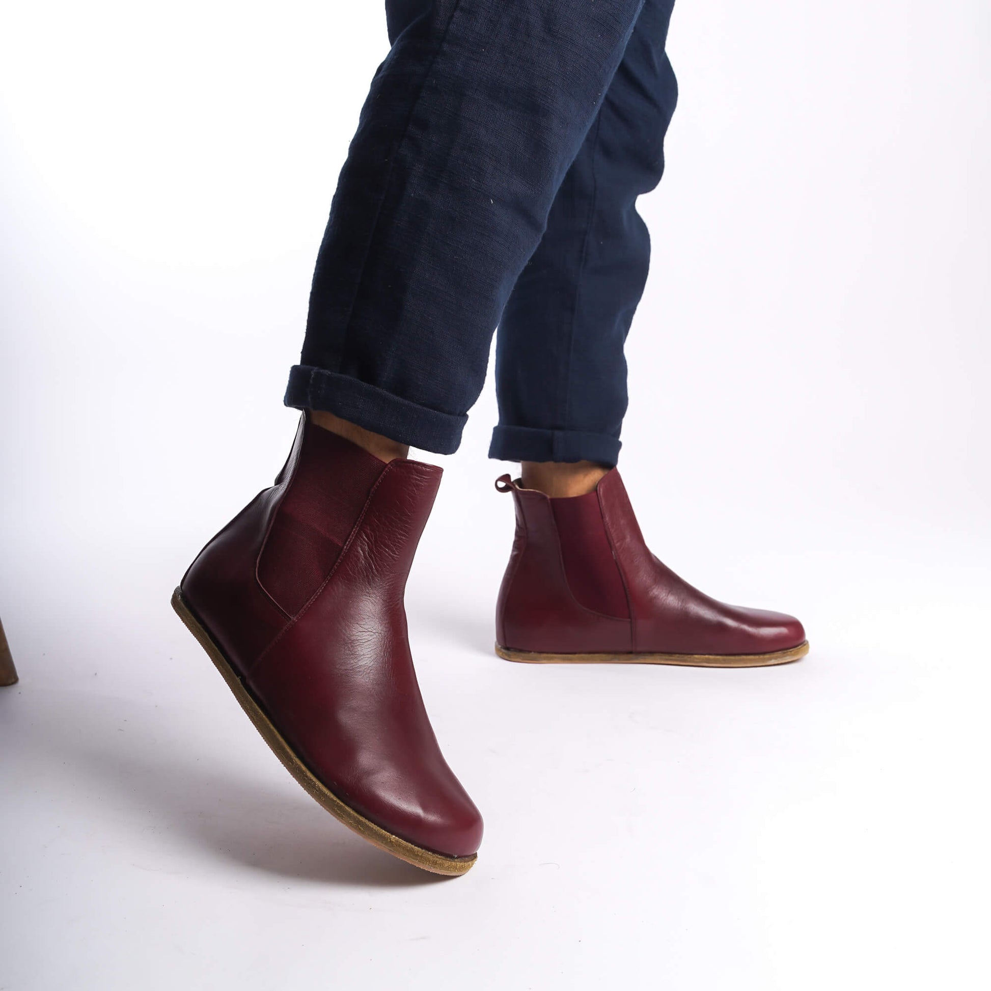 Side view of men's burgundy Chelsea boots, showcasing the minimalist design and rich leather material.