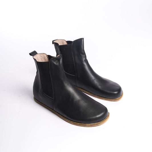 Pair of black Chelsea boots for men, crafted from genuine leather with elastic side panels for a sleek and comfortable fit.