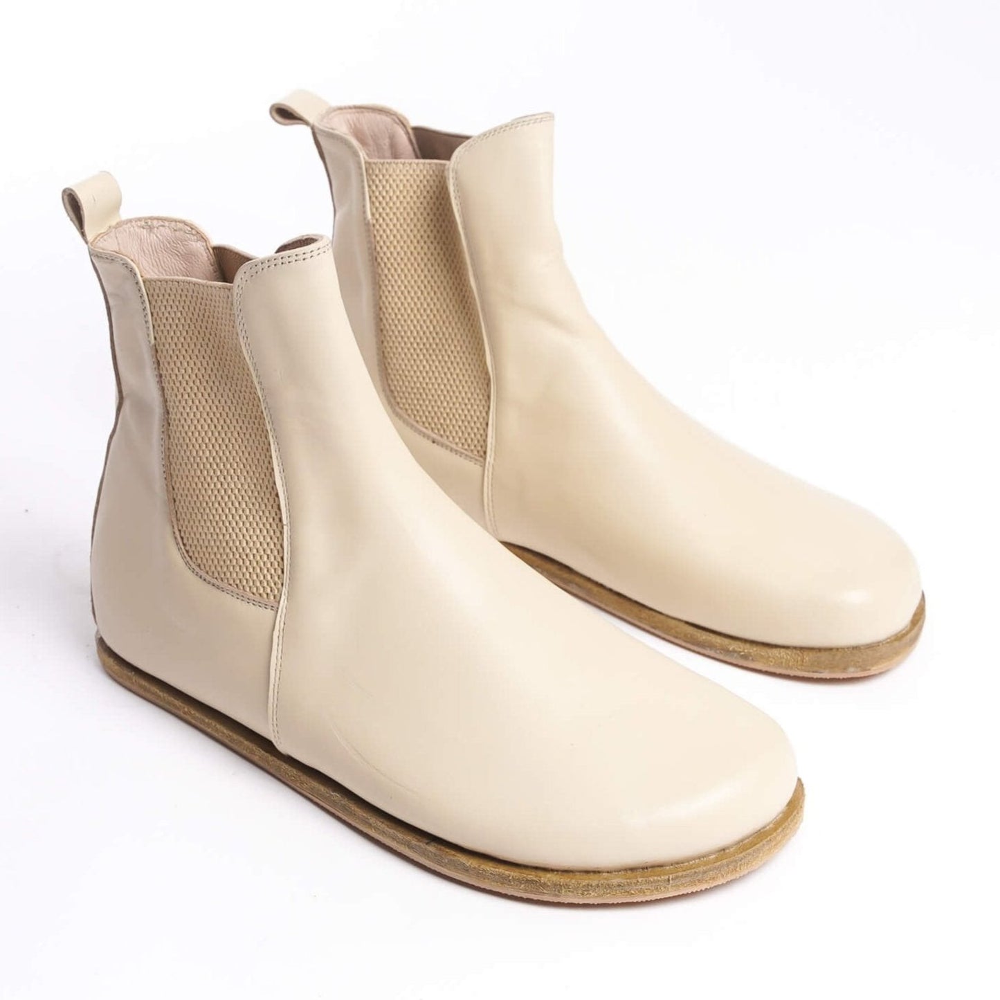 Pair of men's beige-cream Chelsea boots, crafted from genuine leather with elastic side panels for a stylish and comfortable fit.