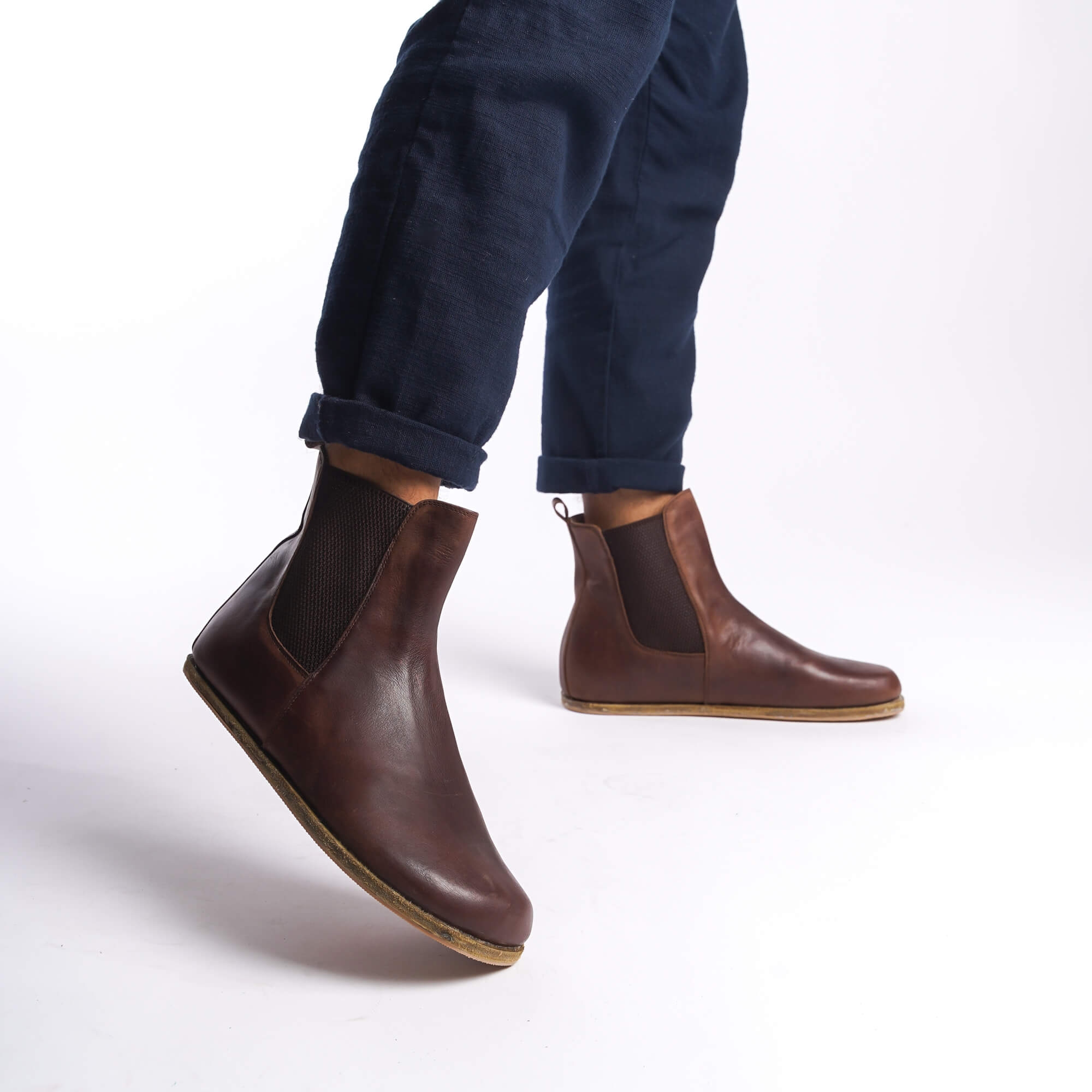 Side view of men's brown Chelsea boots, highlighting the minimalist design and high-quality leather.