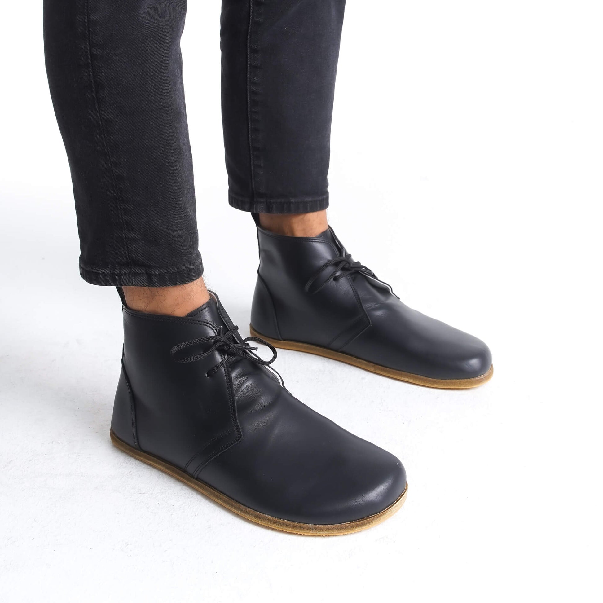 Comfortable black minimalist barefoot boots with zero-drop sole, designed for natural walking.