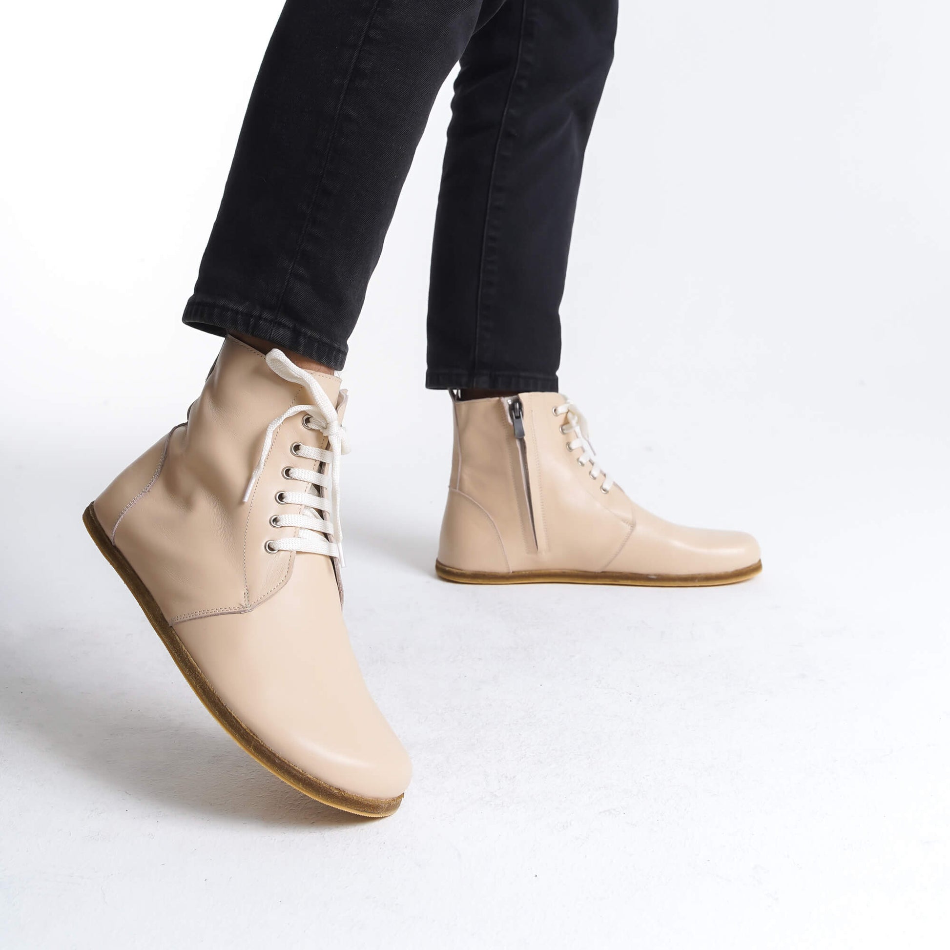 Chic cream barefoot winter boots with a lace-up front and zipper for easy wear. Made from durable leather, they ensure all-day comfort and a fashionable look in cold weather.