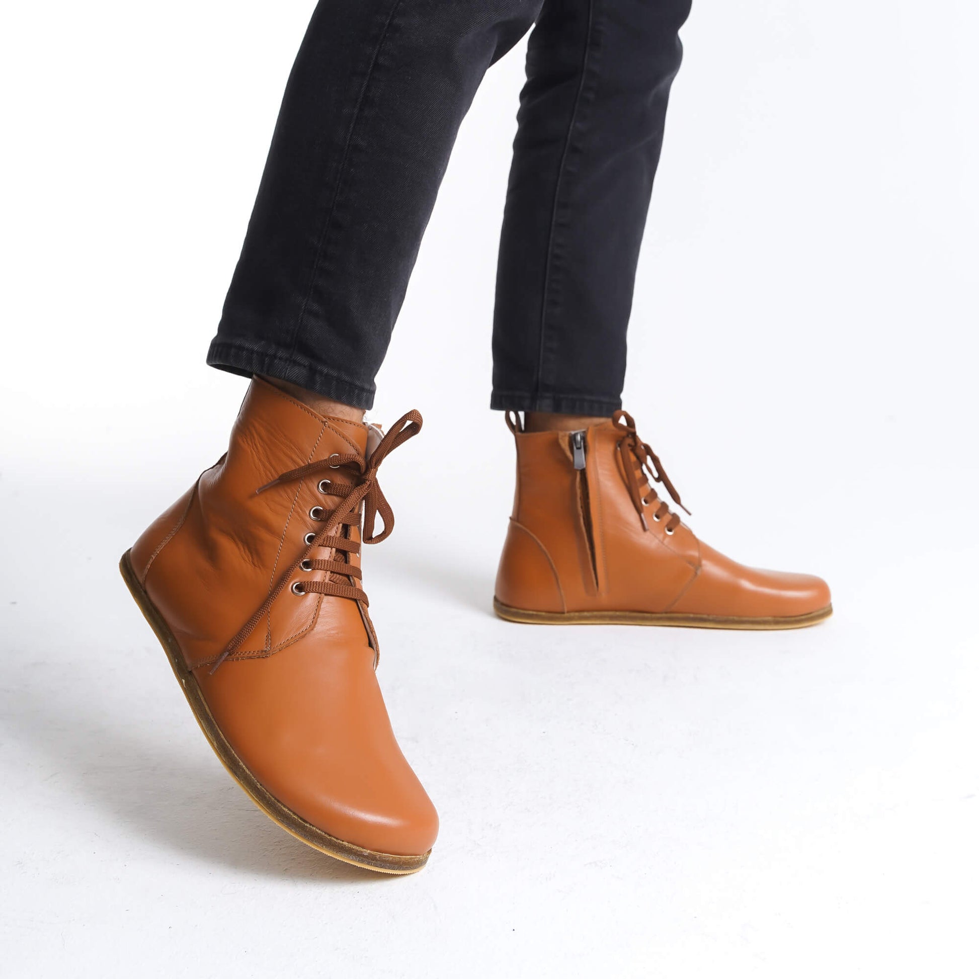 Chic tan barefoot winter boots with a lace-up front and zipper for easy wear. Made from durable leather, they ensure all-day comfort and a fashionable look in cold weather.