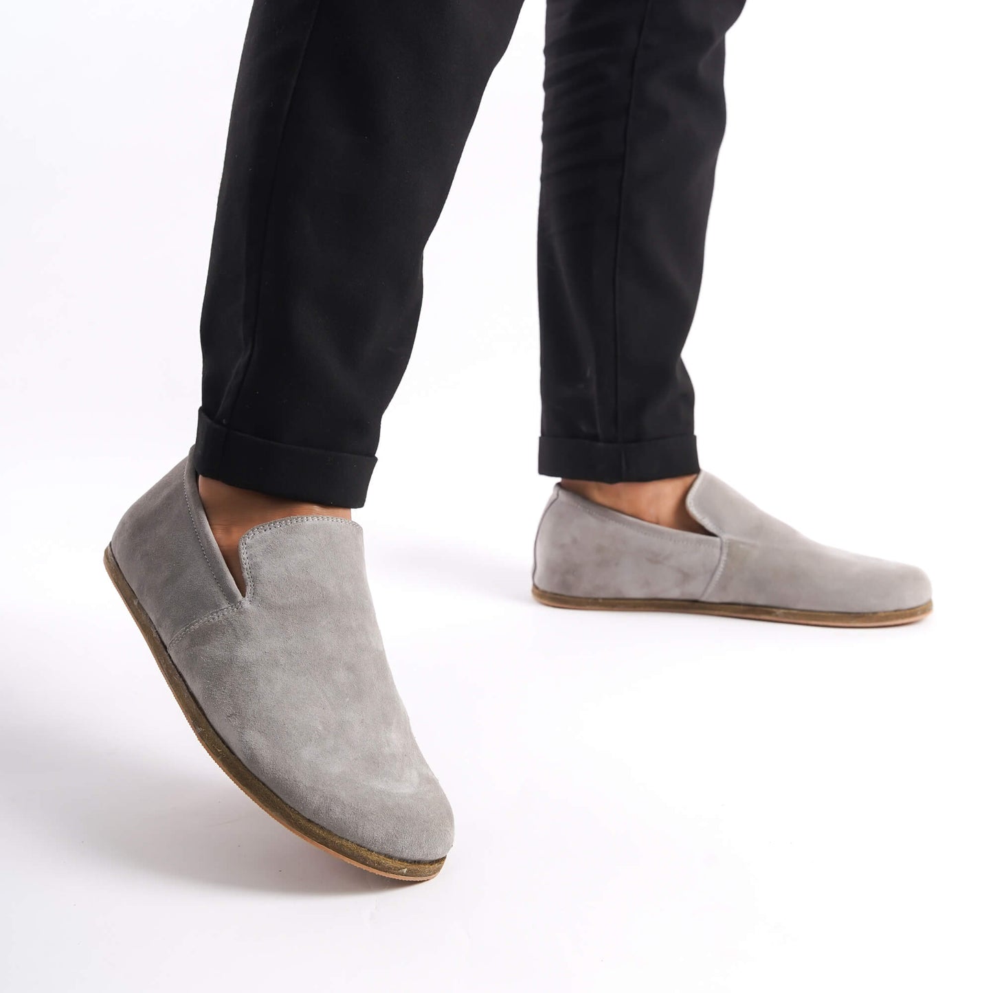 Gray suede Aeolia Leather Barefoot Men's Loafers with a wide toe box, shown on feet with black pants for a sleek and versatile look.