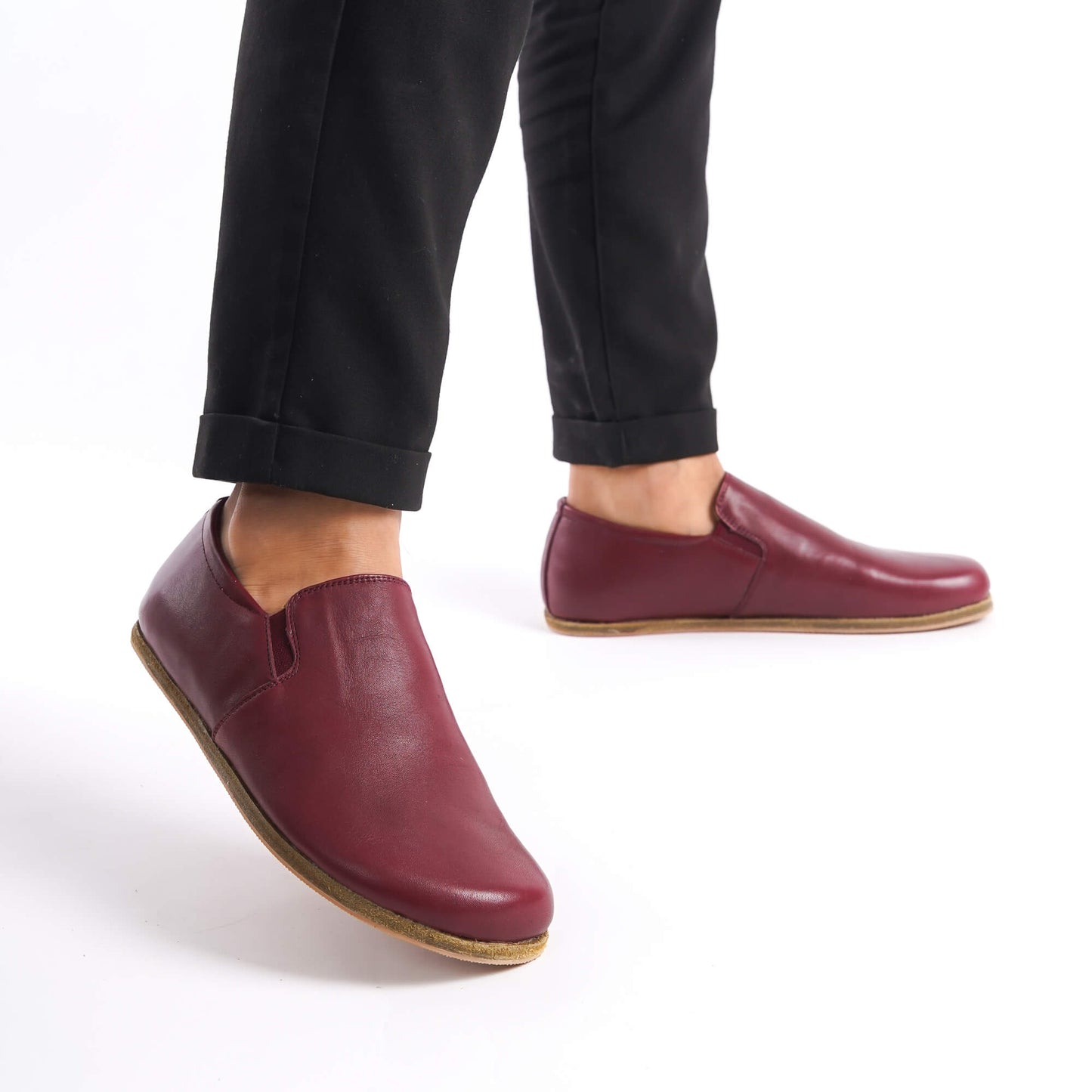 Side view of Ionia Leather Barefoot Men's Loafers in burgundy worn with black pants, emphasizing their sleek and stylish look.