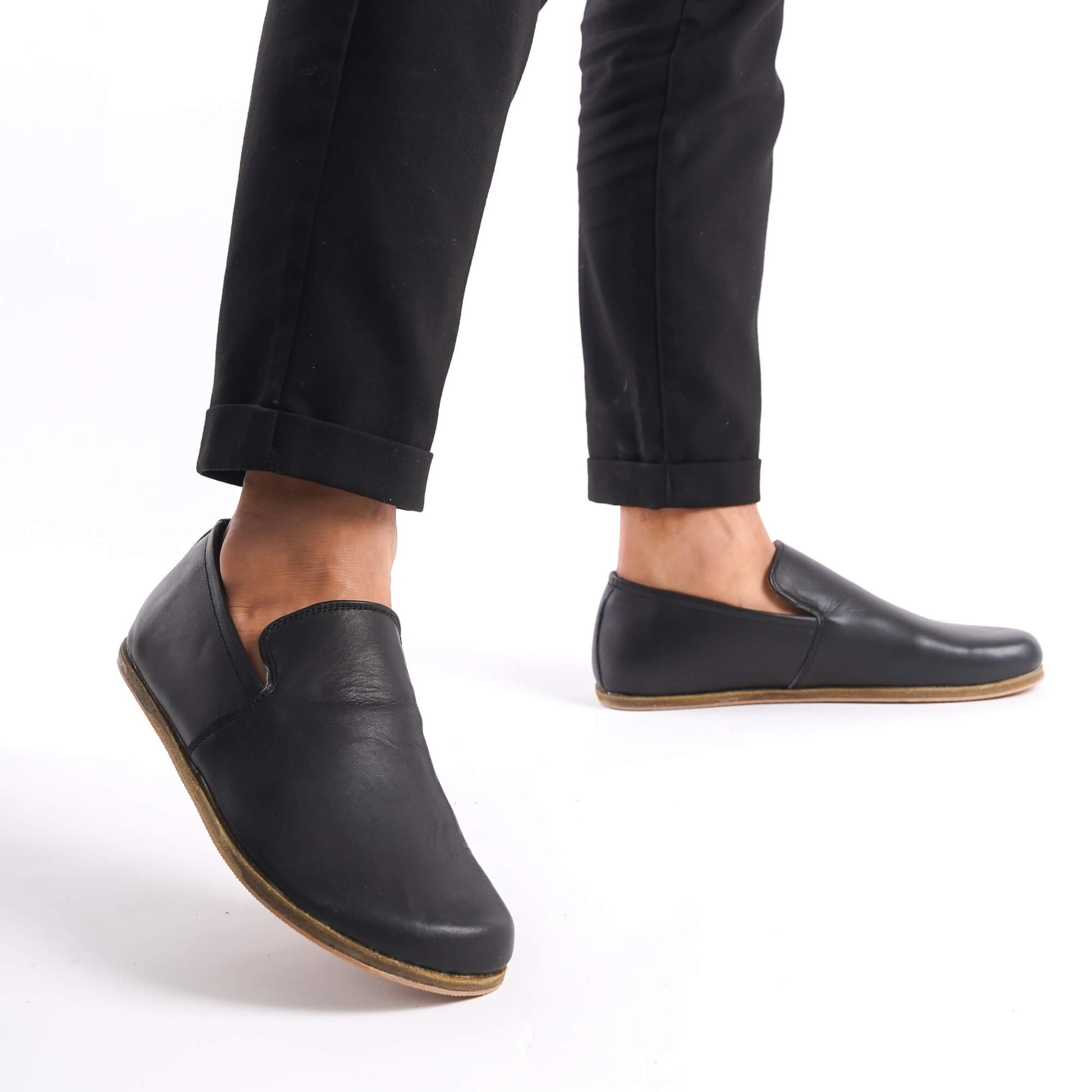 Men's feet wearing Aeolia Leather Barefoot Men Loafers in black with black pants - shop at pelanir.com.