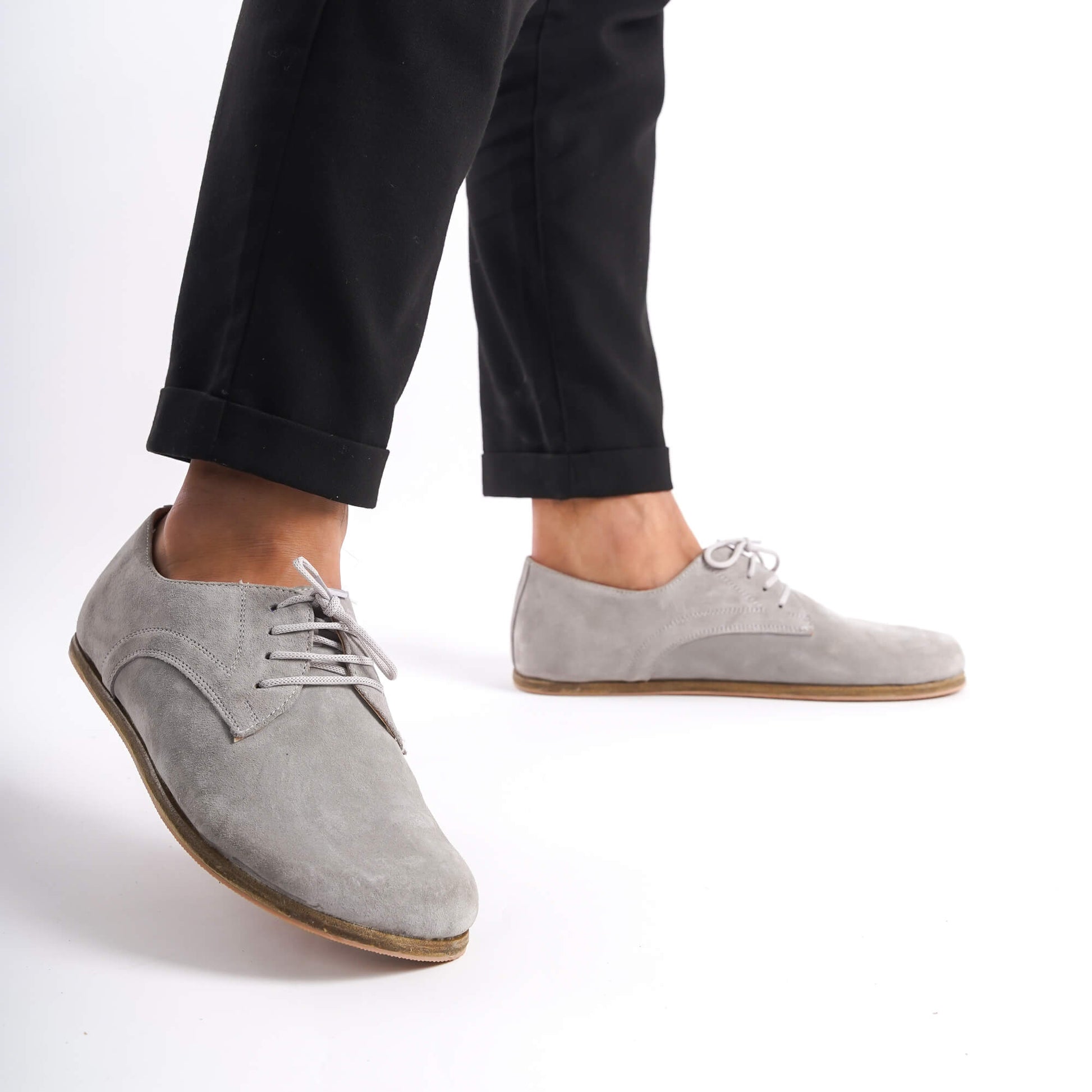 Walking shot of Locris Leather Barefoot Men's Oxfords in gray suede, highlighting their natural fit and improved foot health benefits.