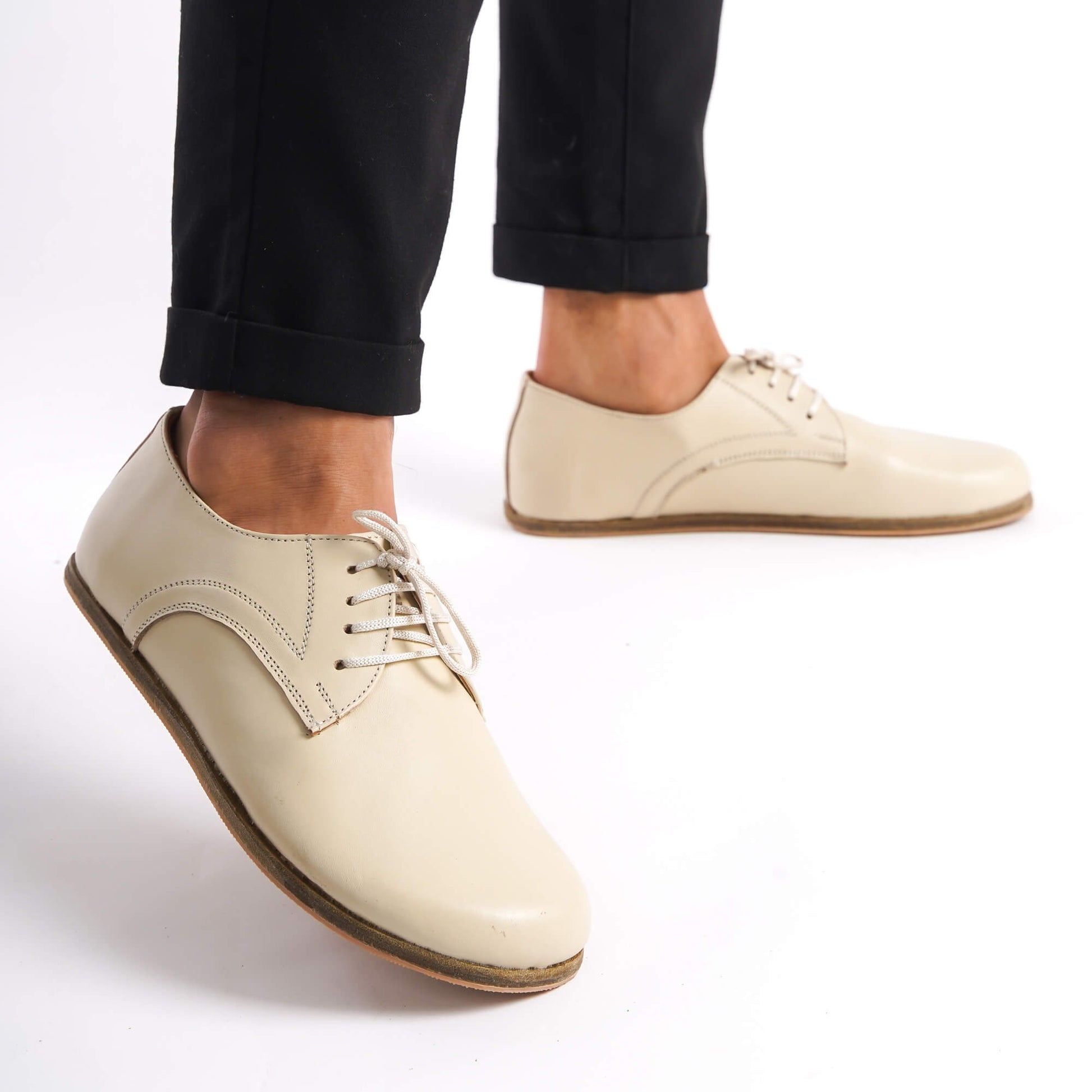 Man posing in beige Locris Leather Barefoot Oxfords, emphasizing their minimalist design and fit.