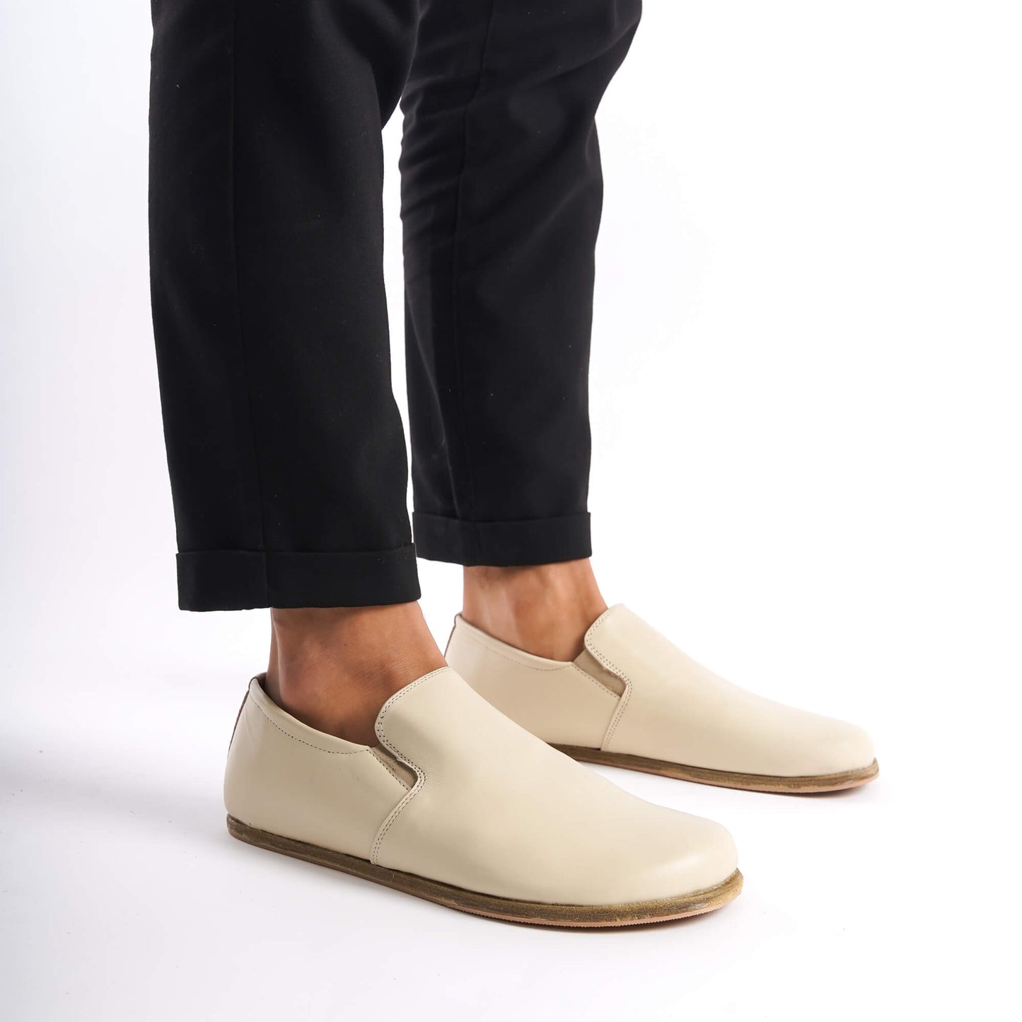 Side view of Ionia Leather Barefoot Men Loafers in beige, paired with black pants, emphasizing the sleek and comfortable design.