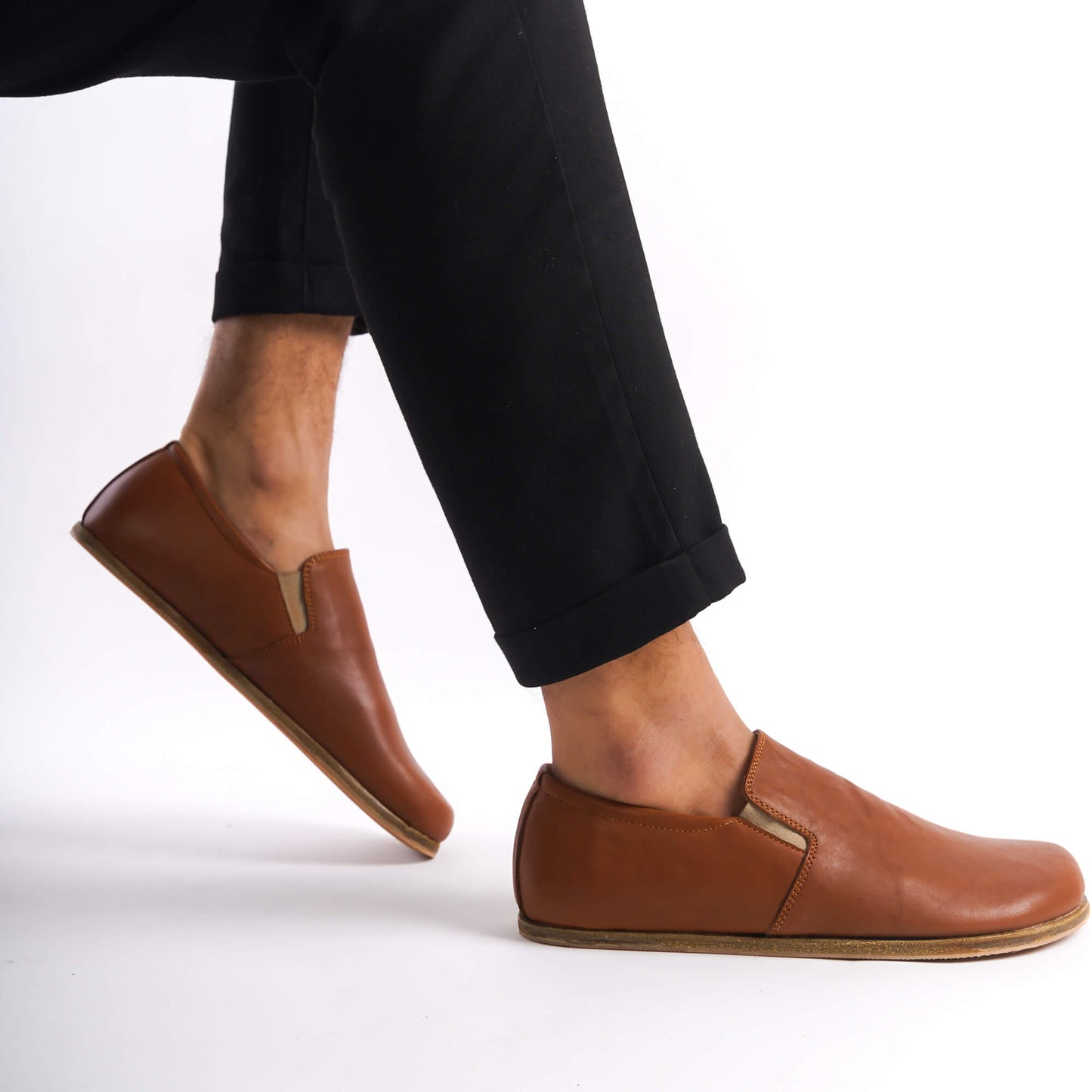 Tan brown Ionia leather barefoot loafers in motion, highlighting the flexibility and lightweight design perfect for everyday wear. Visit pelanir.com for more!