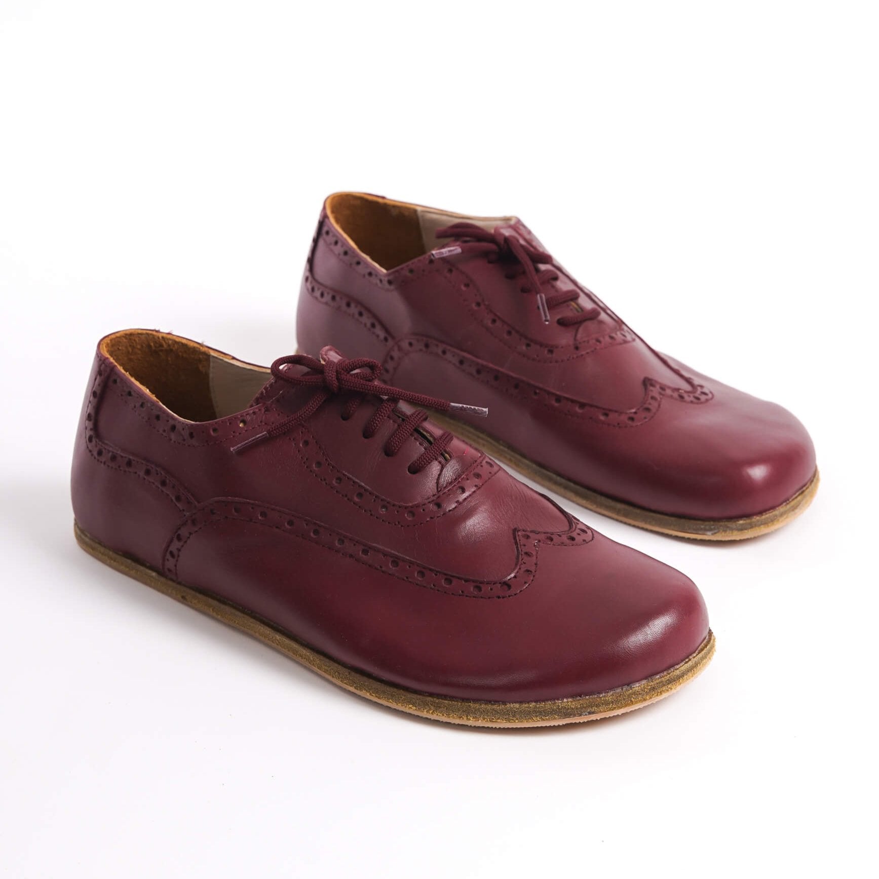 Elegant burgundy leather barefoot Oxfords with brogue details for men – comfortable and stylish.