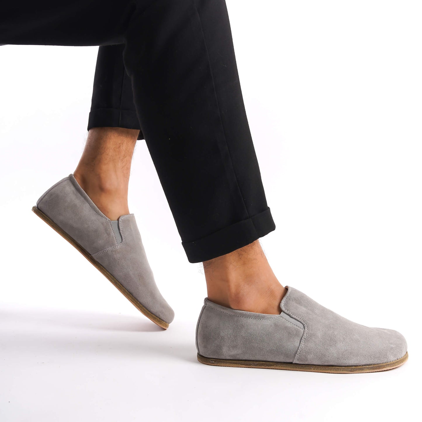 Side view of a man in black pants wearing Gray Suede Ionia Leather Barefoot Men's Loafers, highlighting the natural fit.