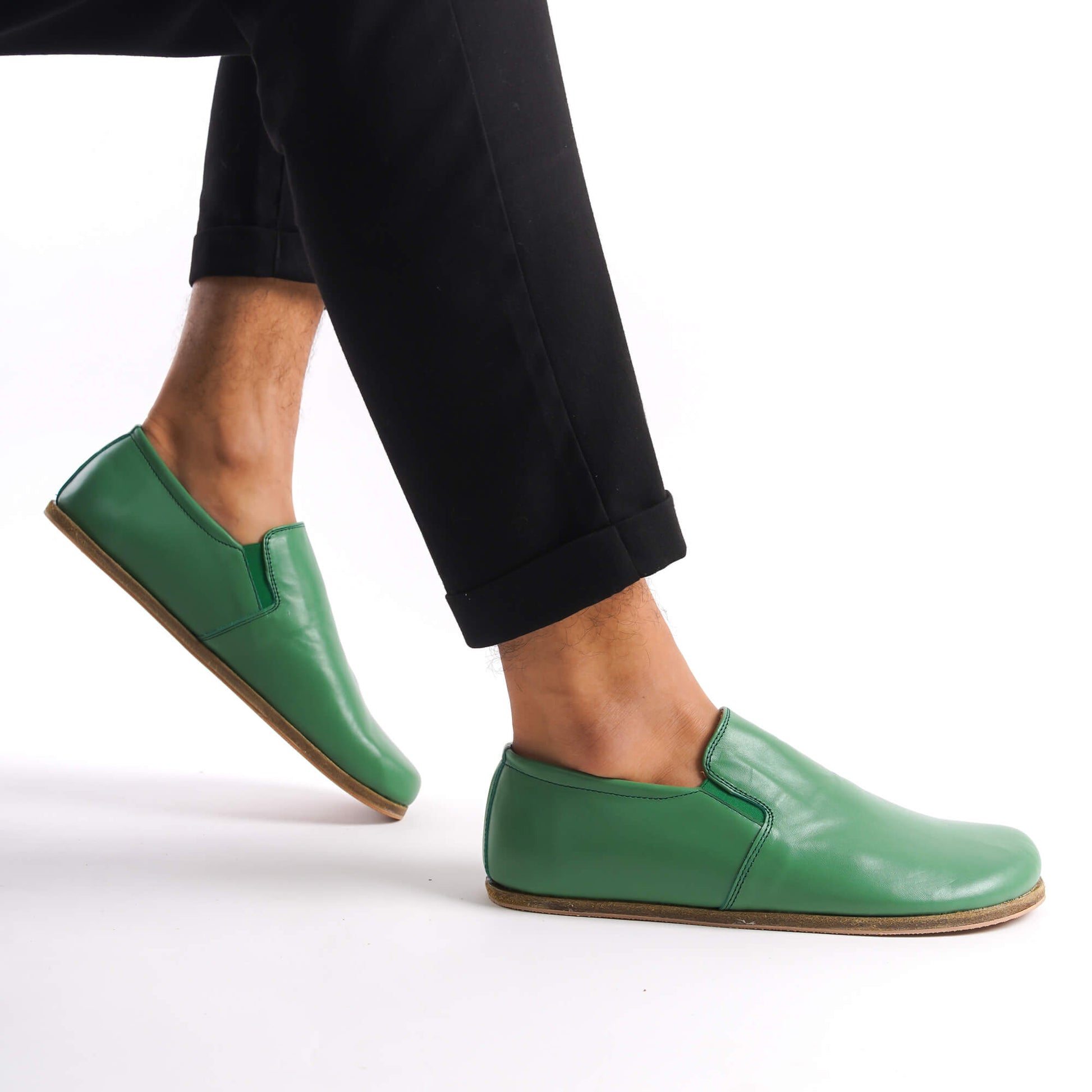 Man walking in green Ionia leather barefoot loafers with black pants. Explore our collection at pelanir.com!