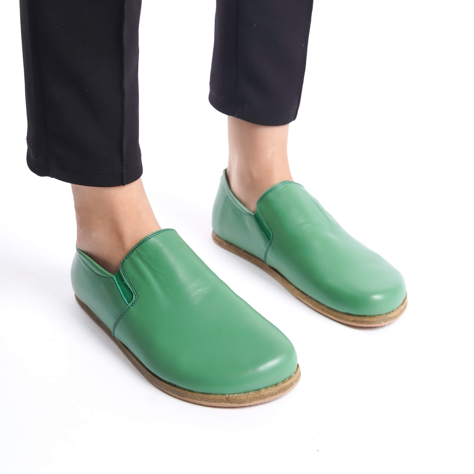 Comfortable green leather barefoot loafers on feet. Natural, zero-drop design from Pelanir.