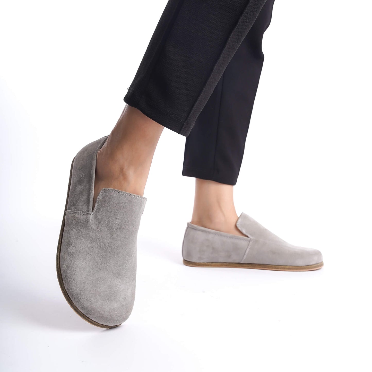Close-up of Aeolia gray suede barefoot women loafers, paired with black pants.