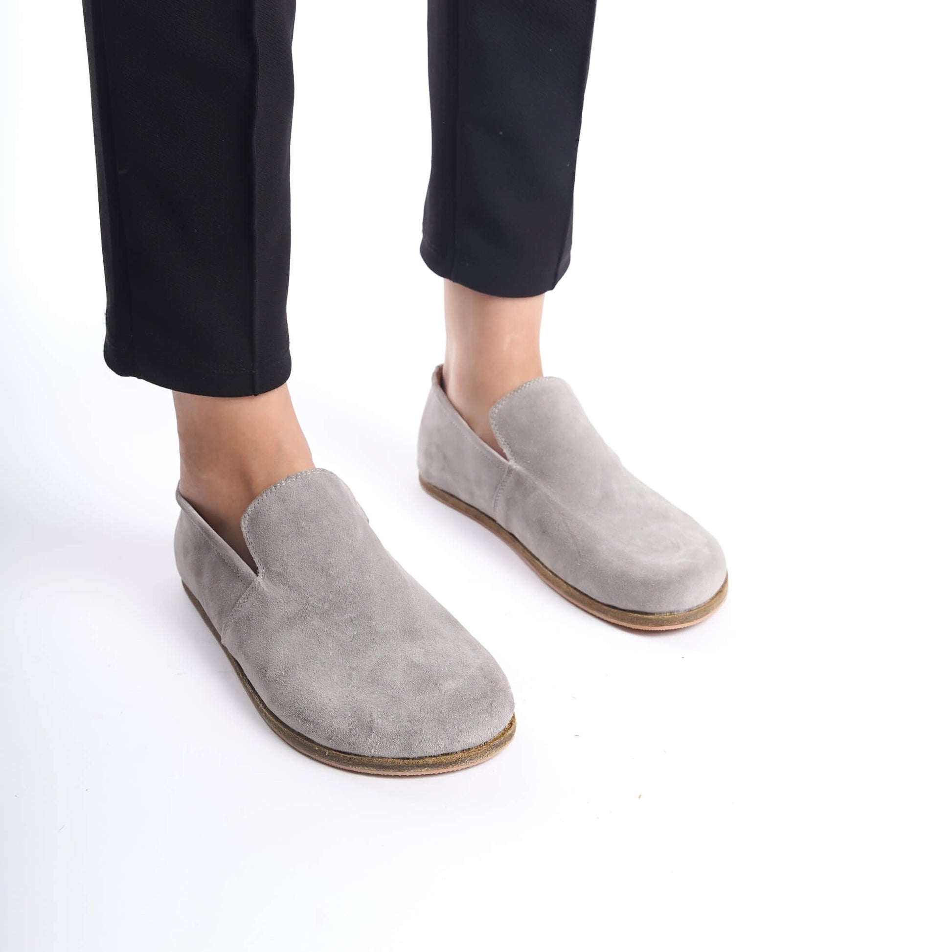 Close-up of Aeolia gray suede barefoot women loafers, paired with black pants.