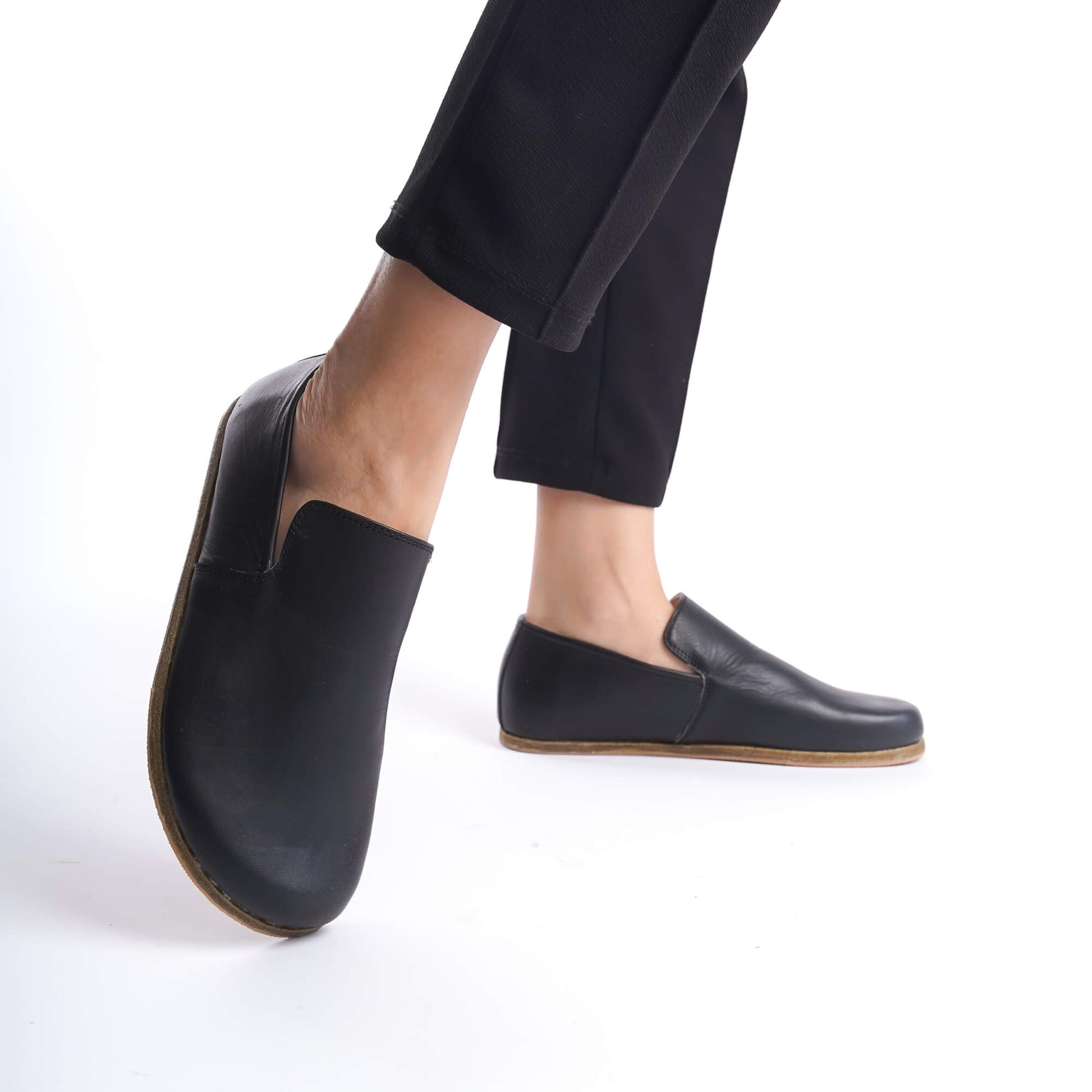 Model Wearing Aeolia Leather Barefoot Women Loafers in Black - Mid-Step Demonstrating the Shoe's Flexibility and Comfortable Fit.